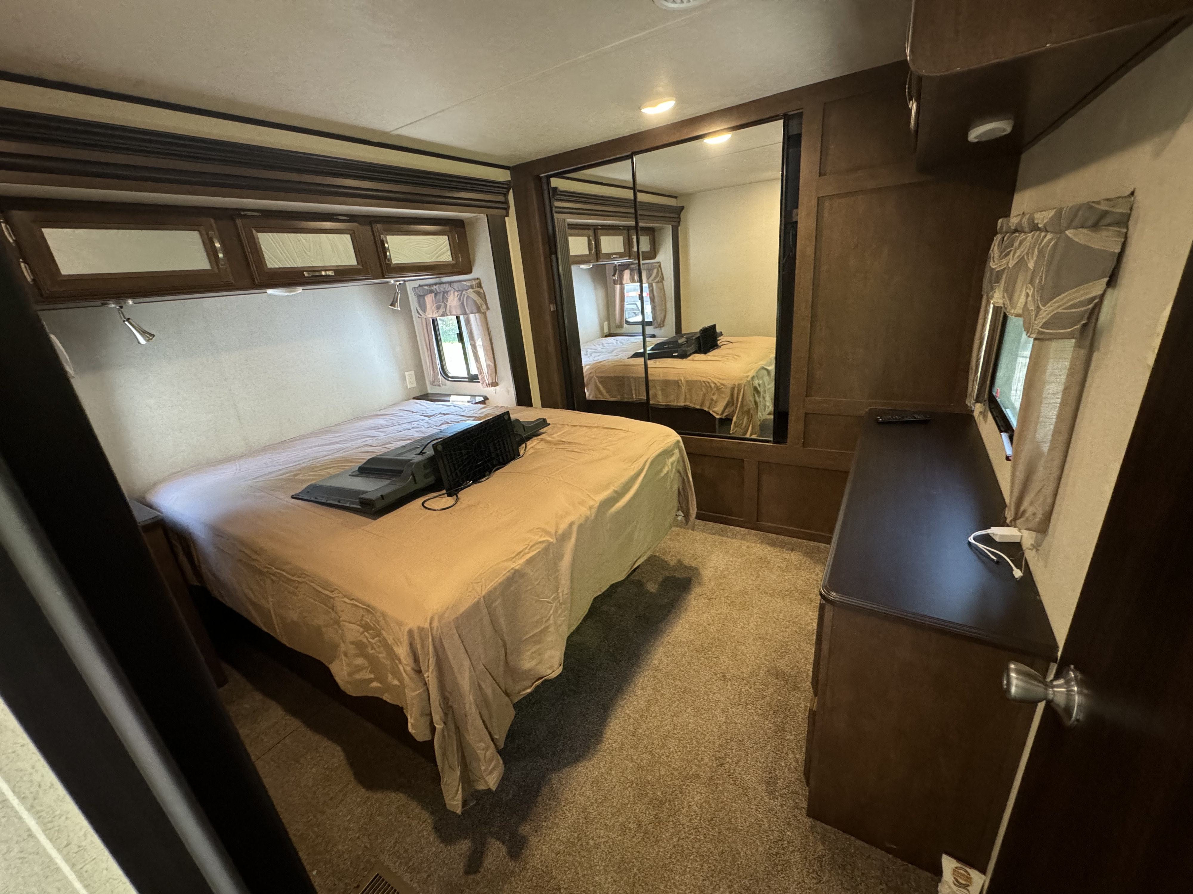 Comfortable RV rental bedroom featuring a bed, overhead cabinets, mirrored closet, and dresser. Perfect for your travels.. Forest River Salem Villa Classic Destination 2017