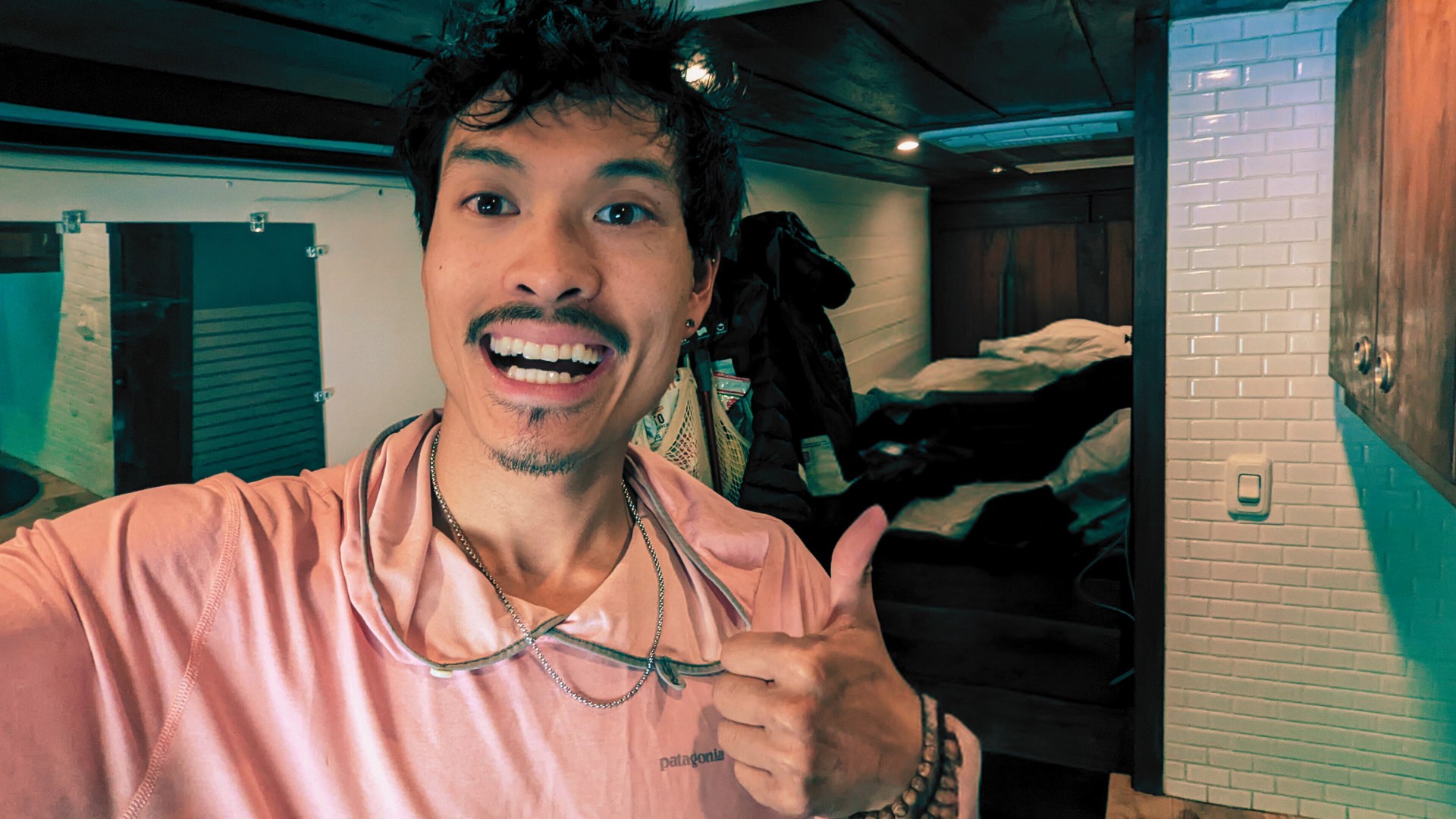 Smiling man gives a thumbs up inside a cozy RV rental, showcasing the compact and functional interior perfect for travel adventures.. Mercedes-Benz Sprinter 2018