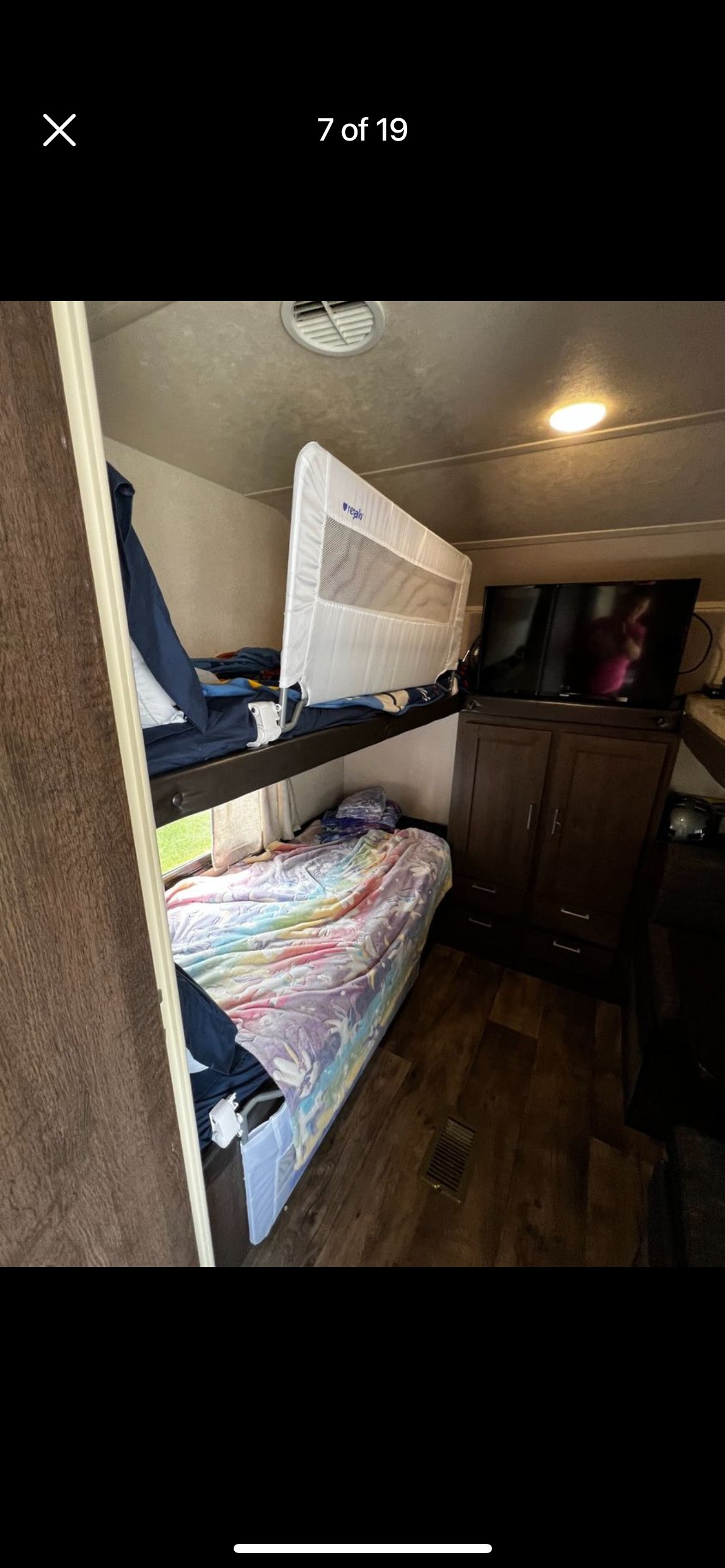 RV rental interior features bunk beds with a safety rail, colorful bedding on the lower bunk, and a TV cabinet.. Forest River Salem 2018