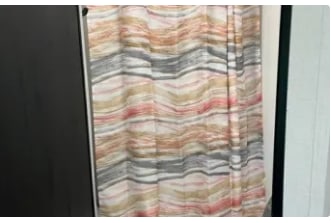 This RV rental features a stylish, wavy curtain in earthy and coral tones, perfect for privacy on your travels.. Dutchmen Kodiak SE 2024