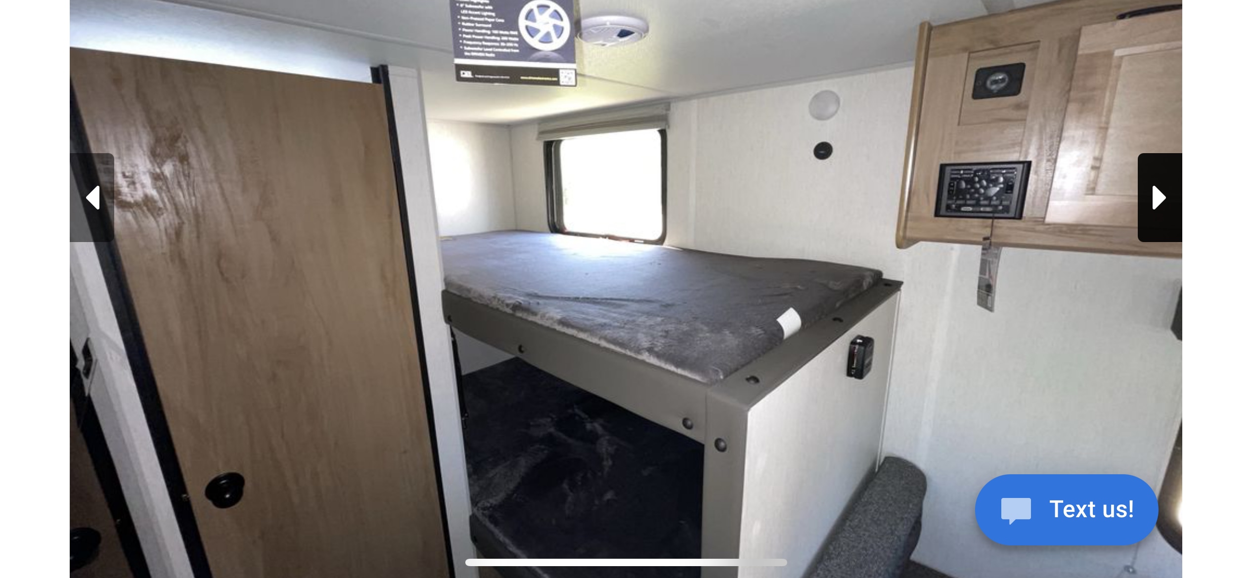 Inside an RV rental, showing a bunk bed setup, control panel, and window. Ideal for compact and efficient living on the road.. Forest River Cherokee Wolf Pup 2024