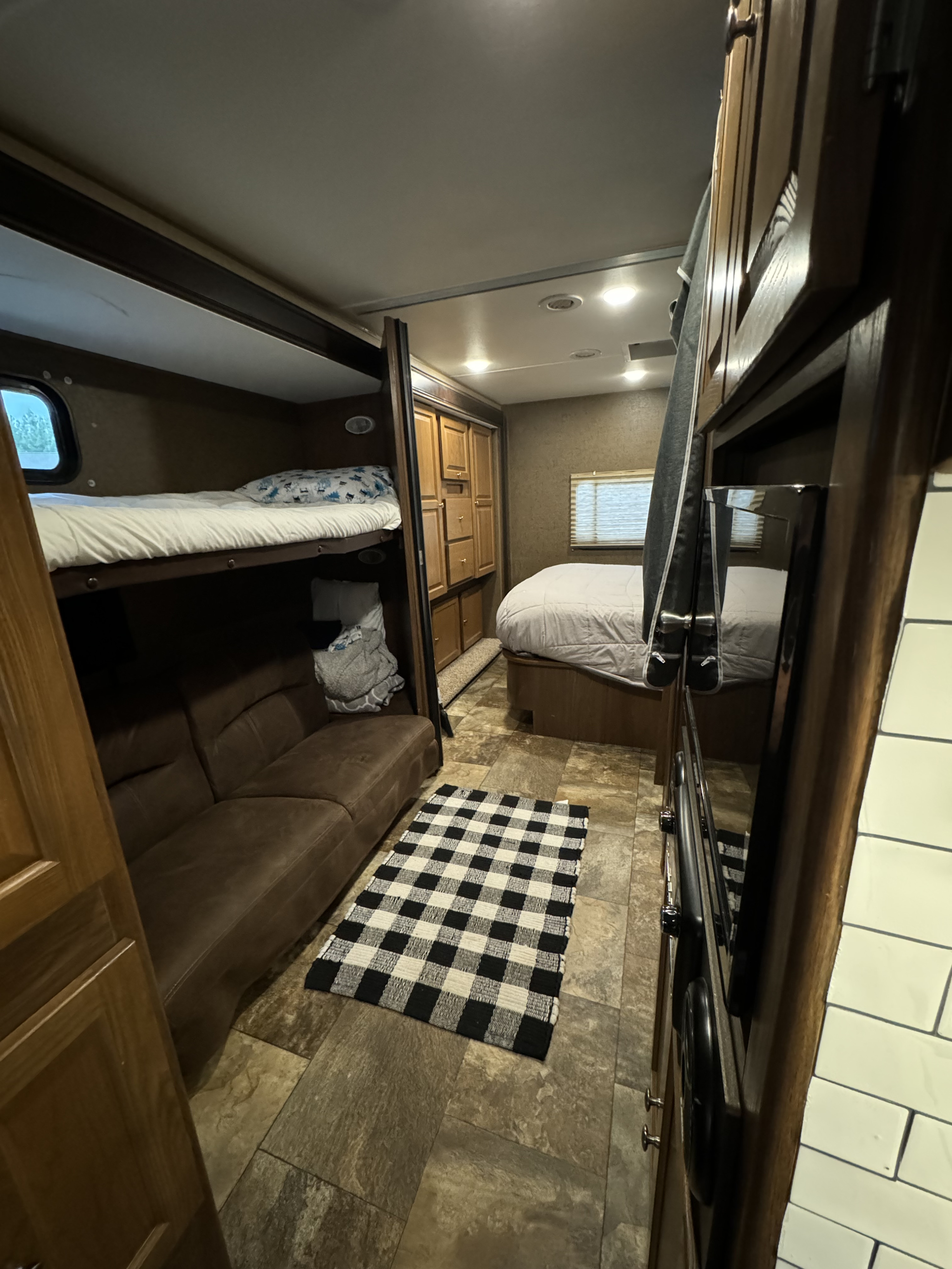RV rental interior: bunk beds, master bed, sofa, and kitchen visible. Enjoy comfortable travel in this mobile home.. Coachmen 310BH Ford 450 Leprachaun 2017