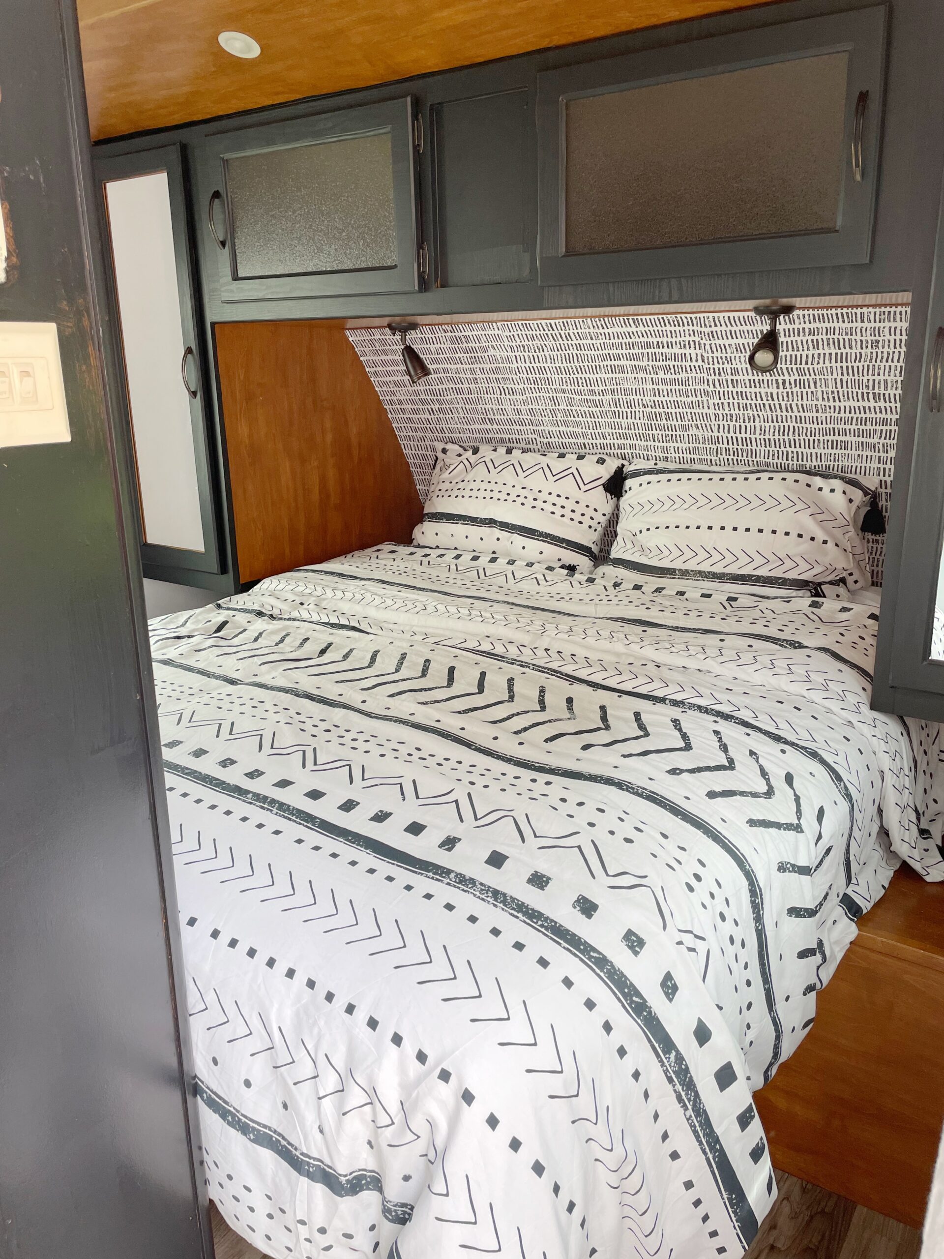 Cozy RV rental bedroom with stylish patterned bedding, overhead cabinets, and reading lights for comfortable stays.. Keystone Ultralite by Bullet 2011