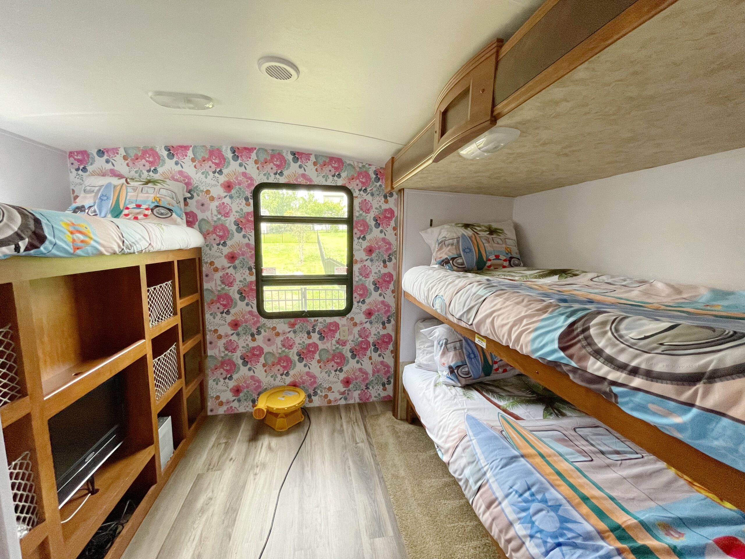Spacious RV rental bedroom featuring colorful bunk beds, charming floral wallpaper, and ample storage for a comfortable stay.. Keystone Ultralite by Bullet 2011