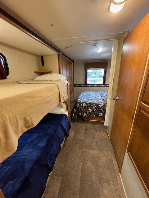Inside this RV rental, find comfortable bunk beds on the left and a private bedroom with a double bed at the end.. Winnebago Minnie Winnie 2017