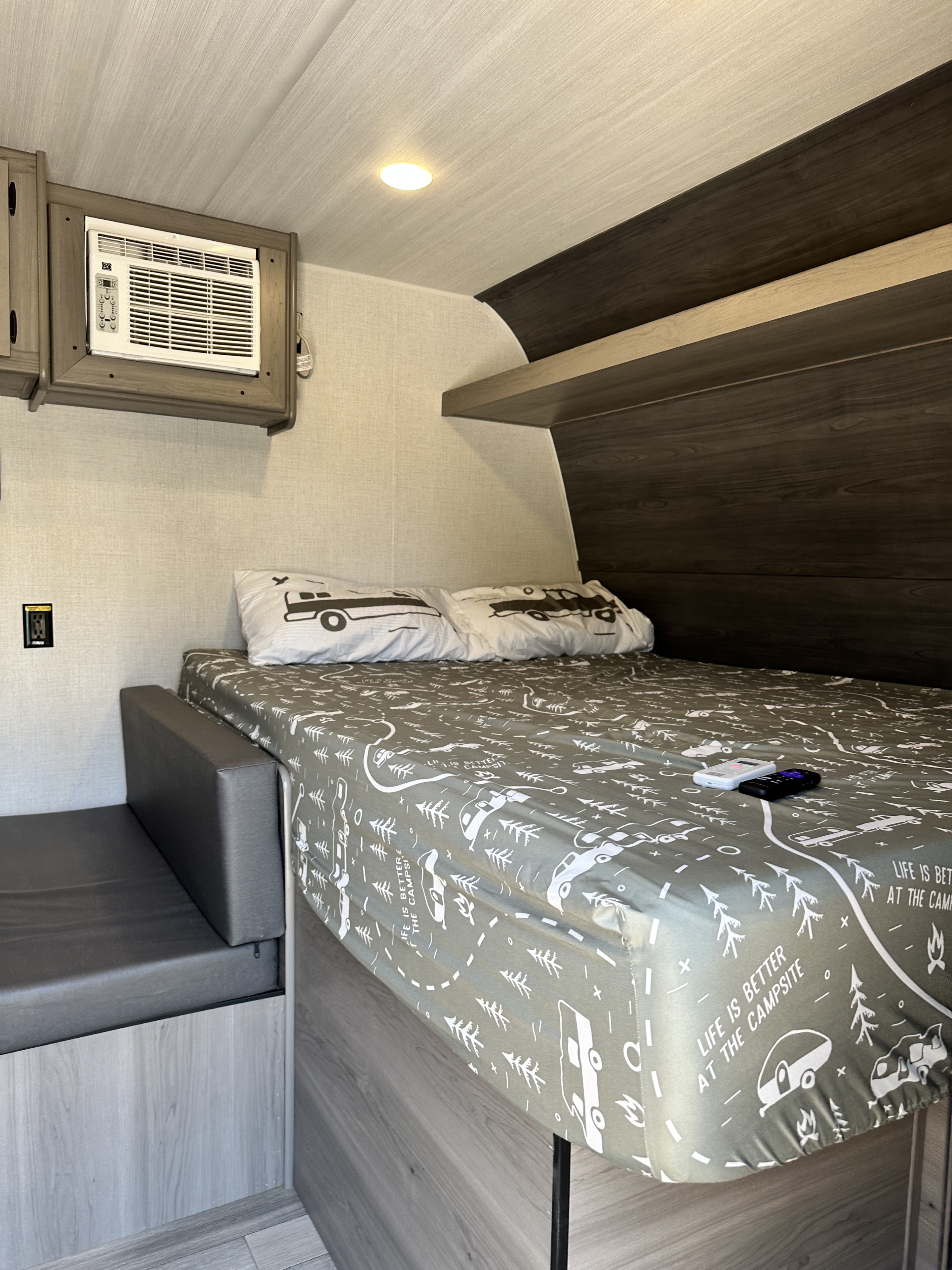 Cozy RV rental interior featuring a themed bed, compact seating, and AC for comfortable travel.. Keystone RV Hideout Sport 2024