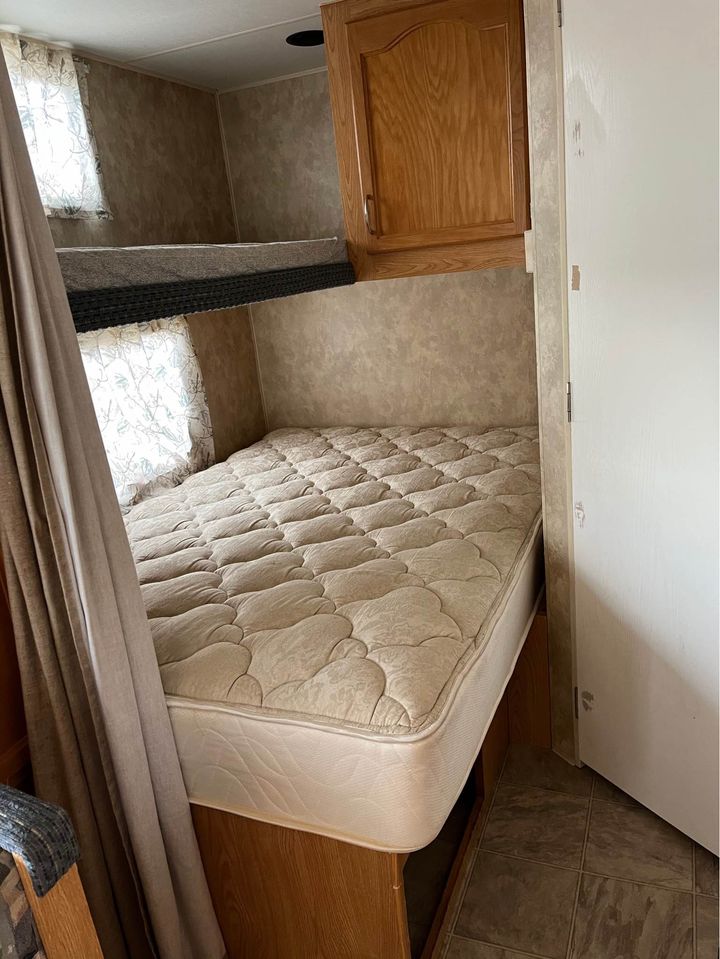 RV rental bunk beds & cozy mattress setup inside, with cabinet & window. Ideal travel accommodation.. Fleetwood Mallard 2007