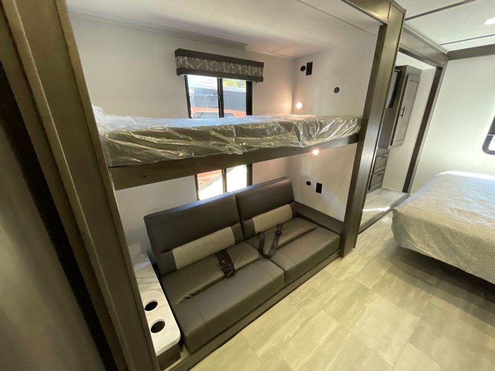 This RV rental interior features bunk beds, a convertible sofa, and a main bed, providing comfortable sleeping space.. FR3 FR3 Motorhome 2024