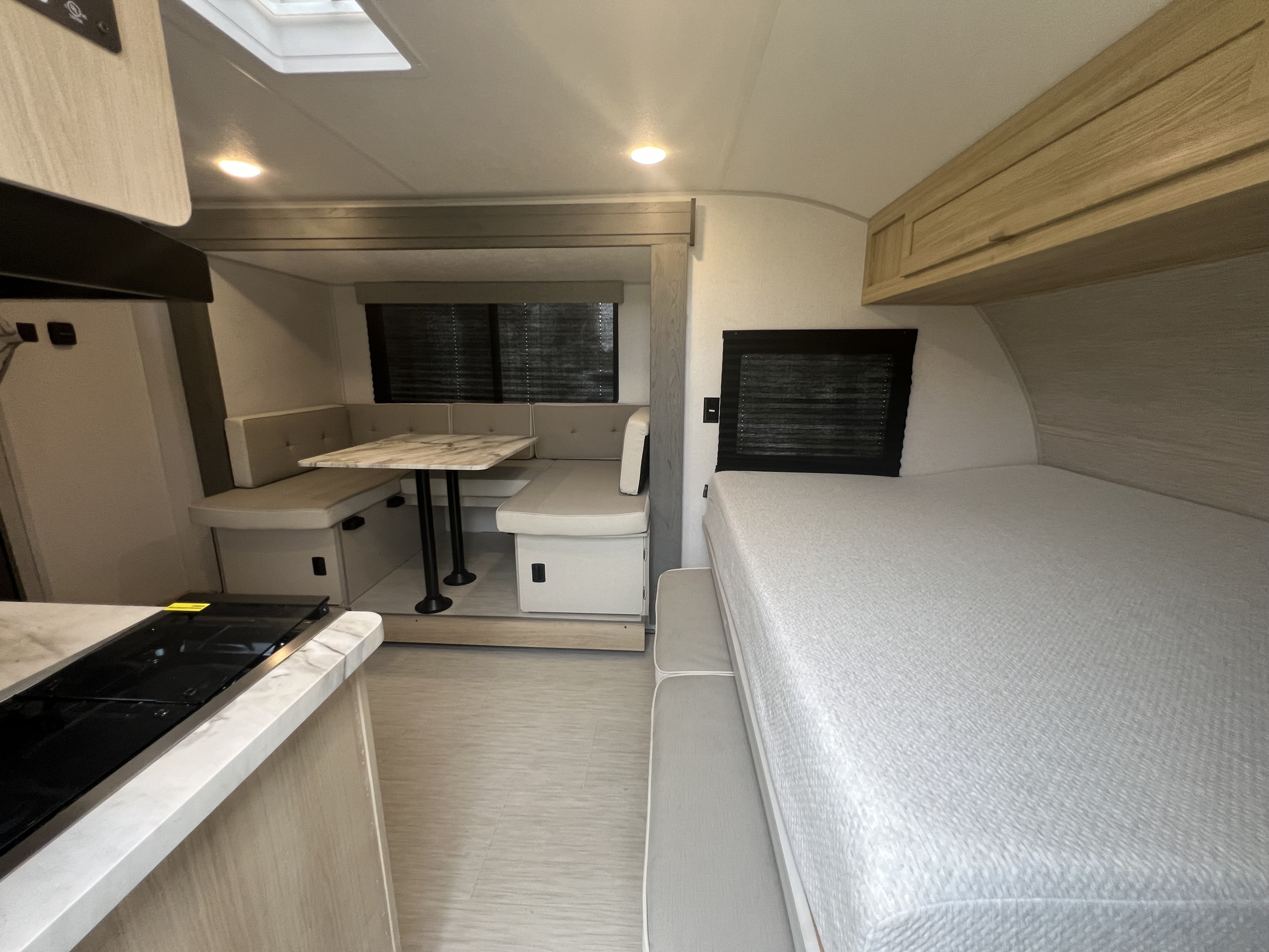 Modern rv rental interior: compact kitchen, cozy dinette with table, and comfortable bed area. Bright, functional design.. Forest River Salem FSX 2023