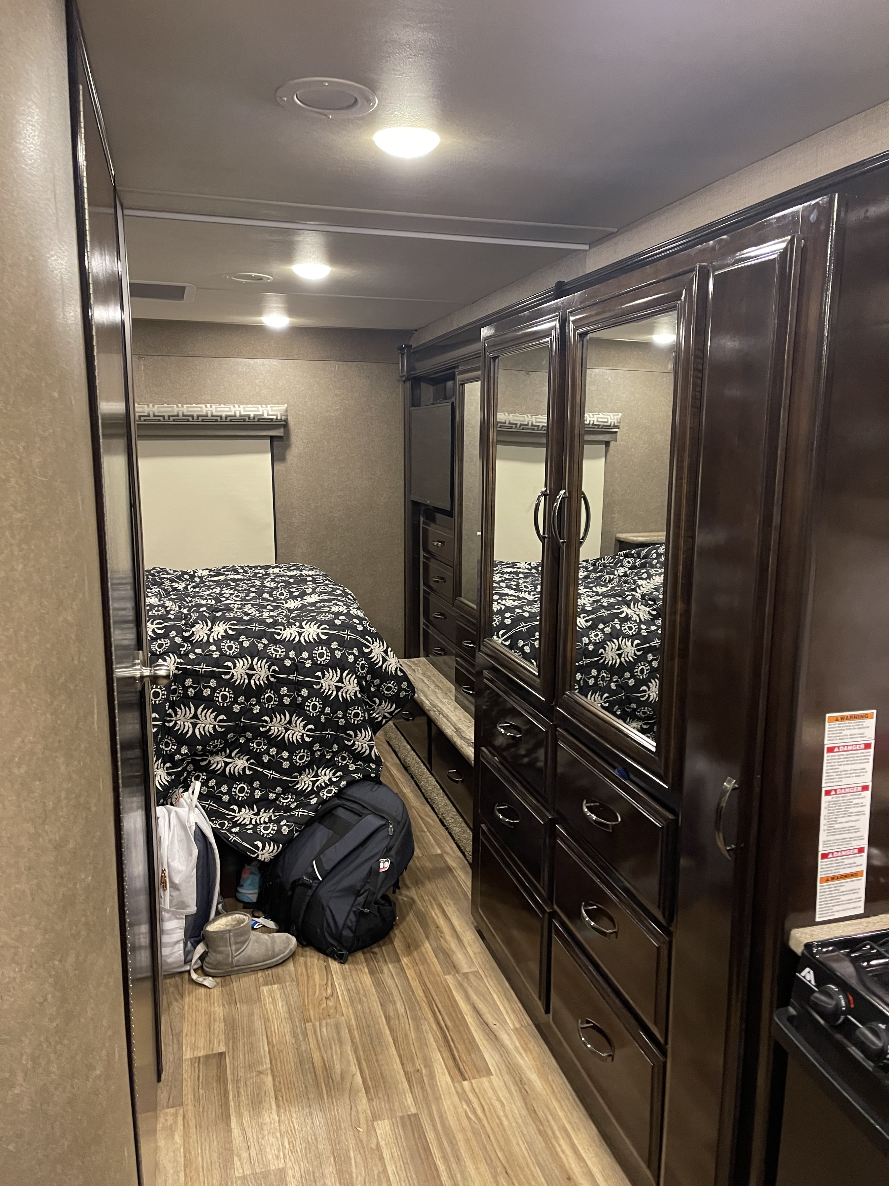 Experience a comfortable RV rental. This interior features a bedroom with bed, mirrored wardrobe, and TV.. Thor Quantum 2018