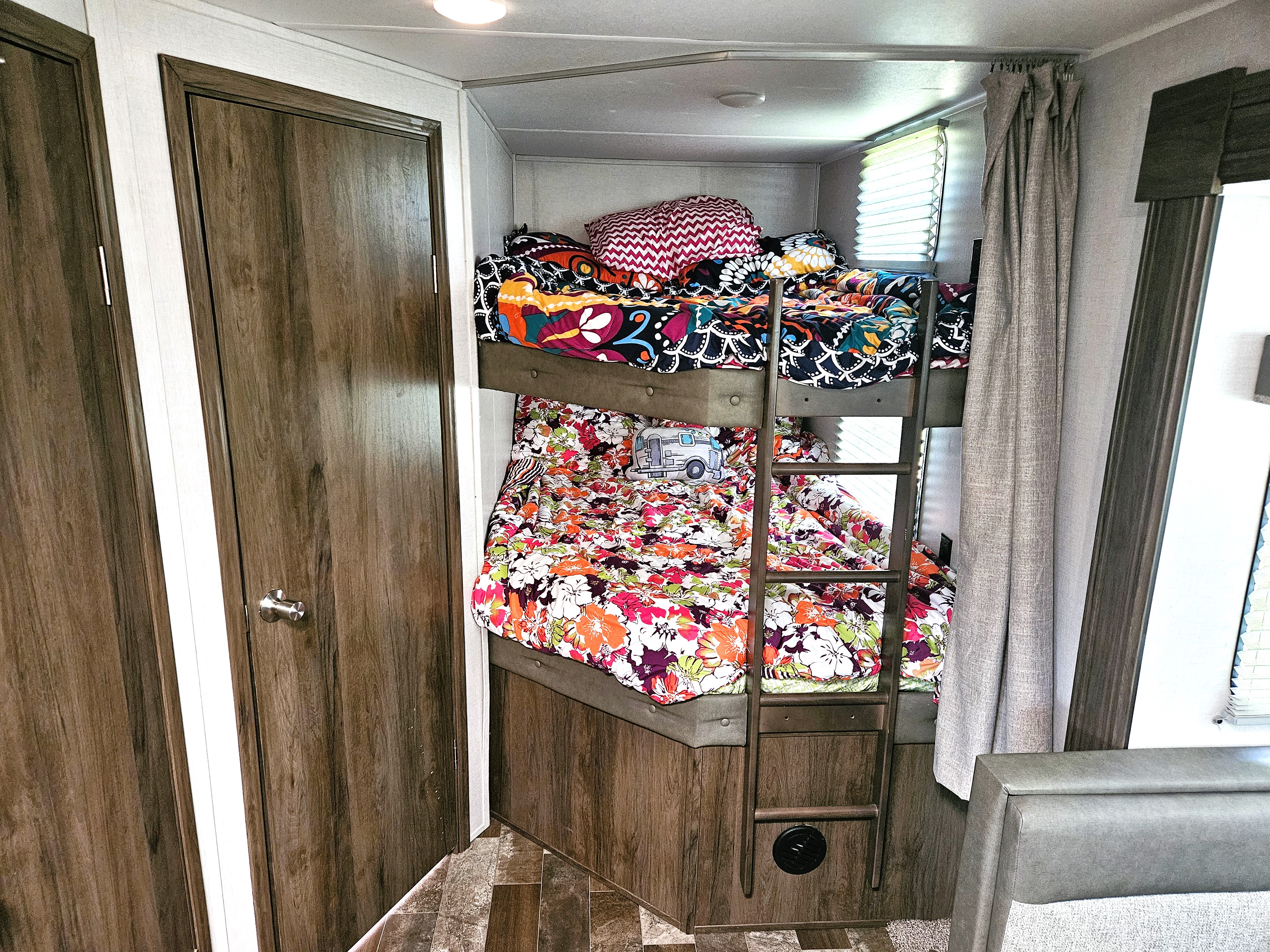 Cozy RV rental interior: colorful bunk beds with vibrant bedding, perfect for family road trips.. East to West Silver Lake 2021