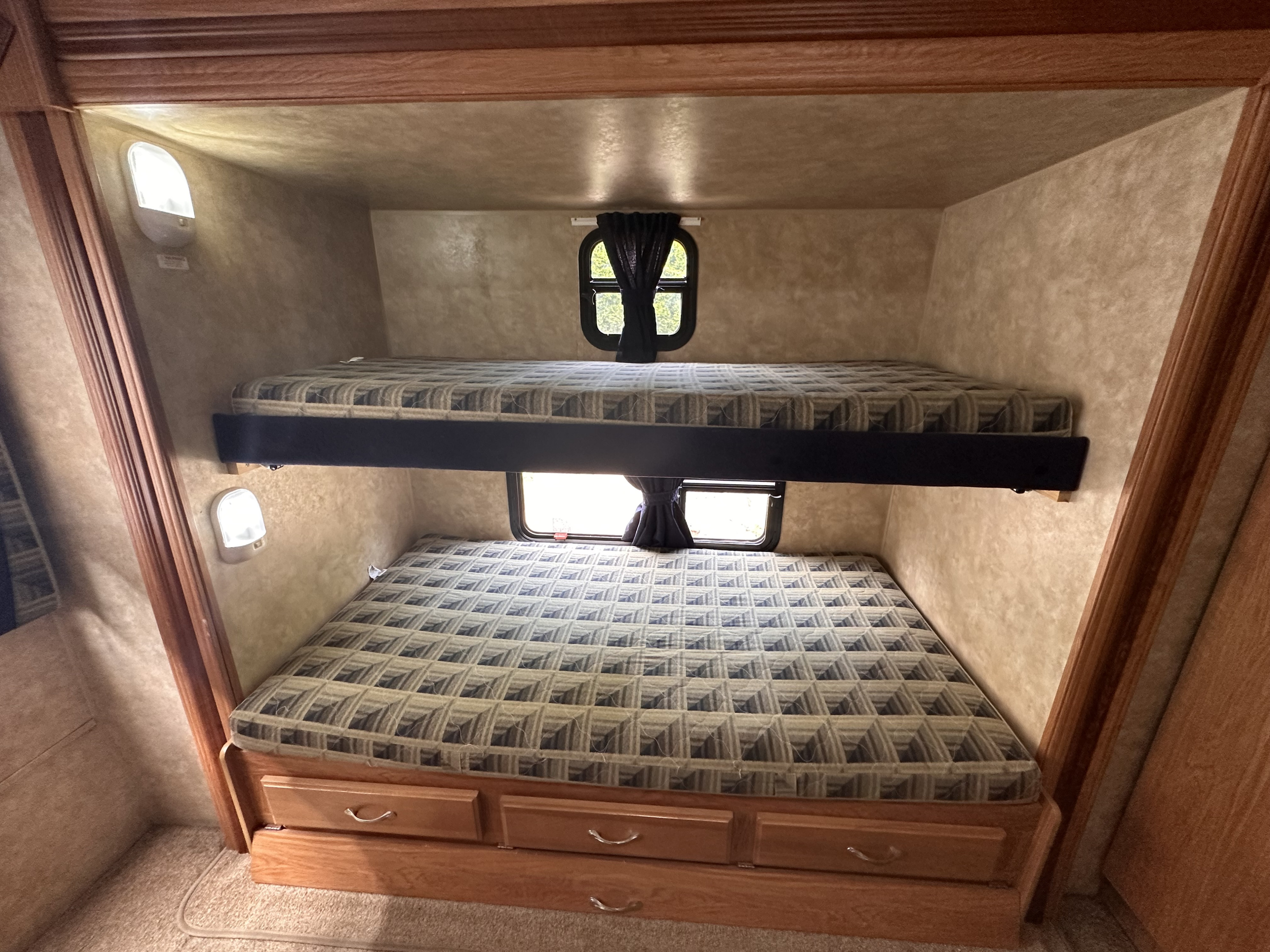Inside an RV rental: cozy bunk beds with individual lights, windows, and under-bed storage.. Jayco Jay Flight G2 2009