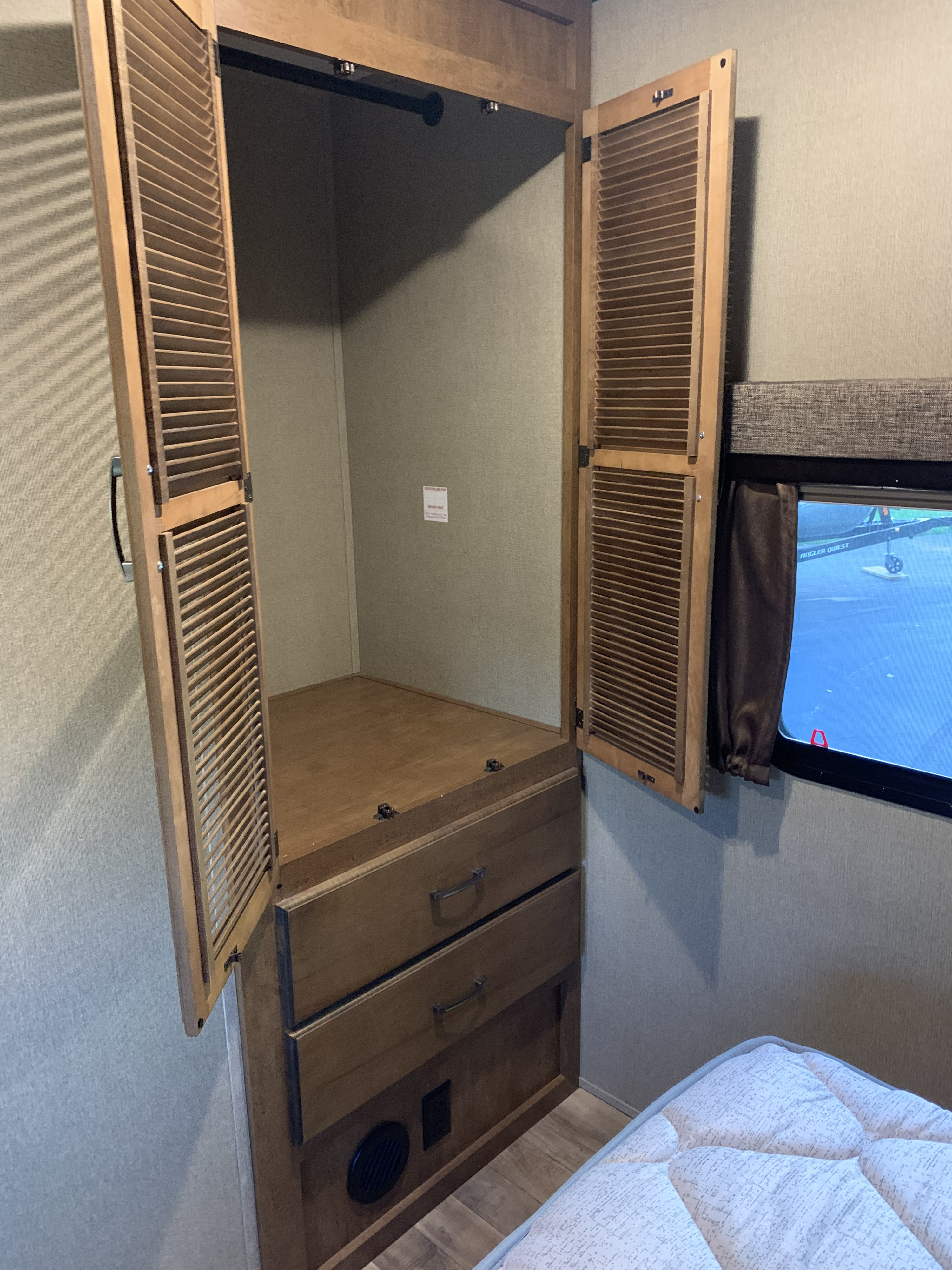 RV rental: Open louvered wardrobe reveals hanging rod & drawers. A comfortable bed and window are also visible.. Reflection BHT33 2018