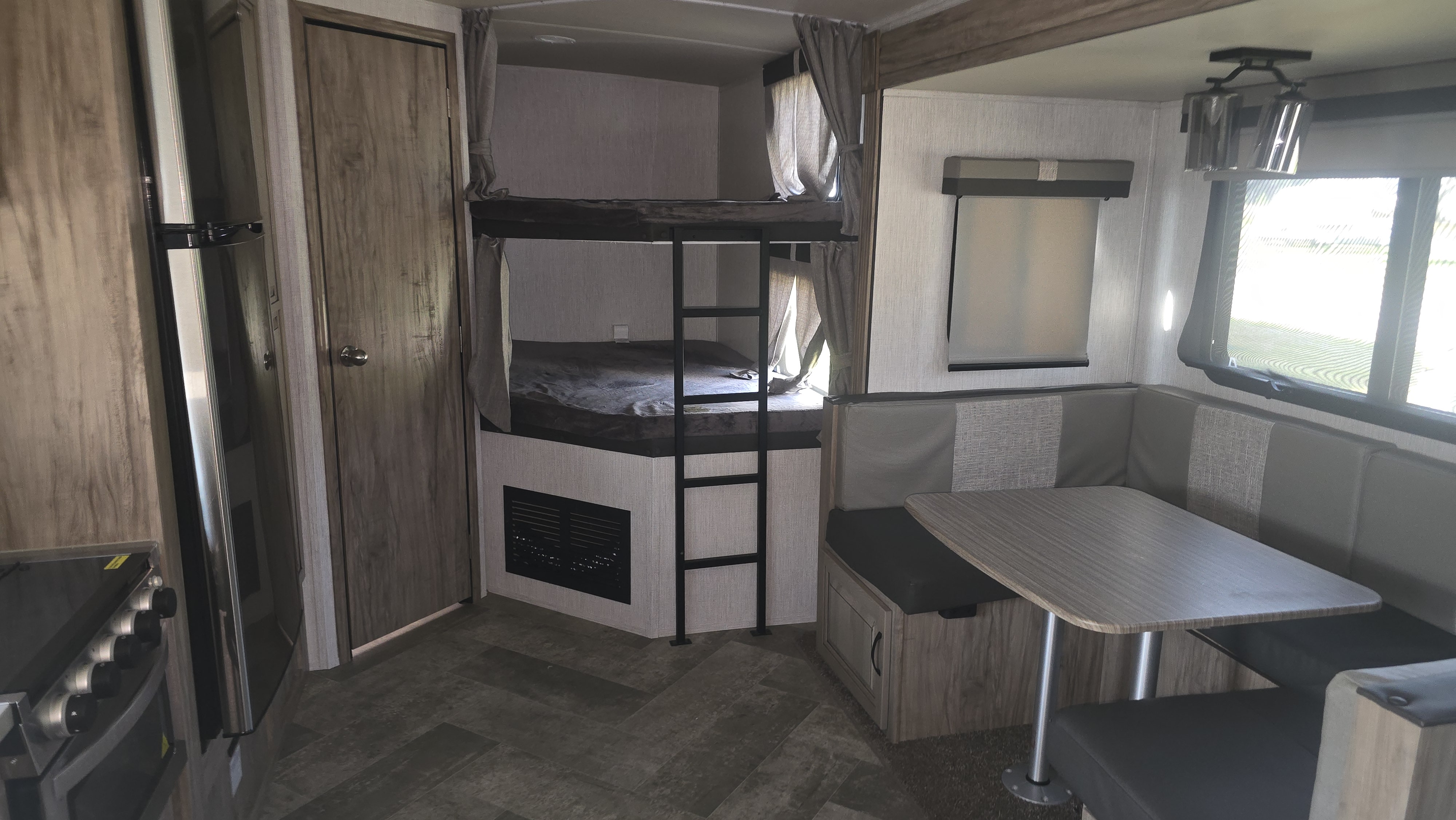 RV rental interior with bunk beds, dinette, and kitchen. A functional and comfortable space for road trips.. Palomino Solaire 2022