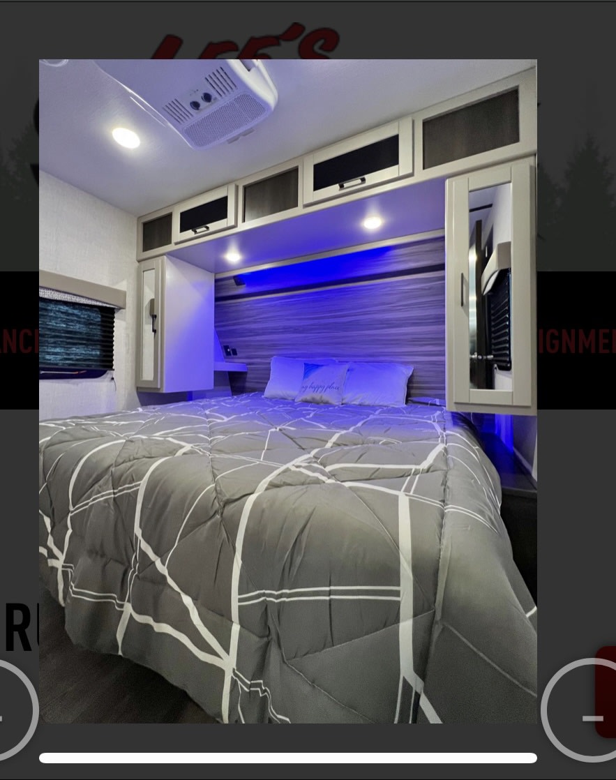 Modern RV rental bedroom featuring a comfy bed, overhead cabinets, and ambient blue lighting for relaxing camping trips.. Crossroads RV Cruiser Aire 2022