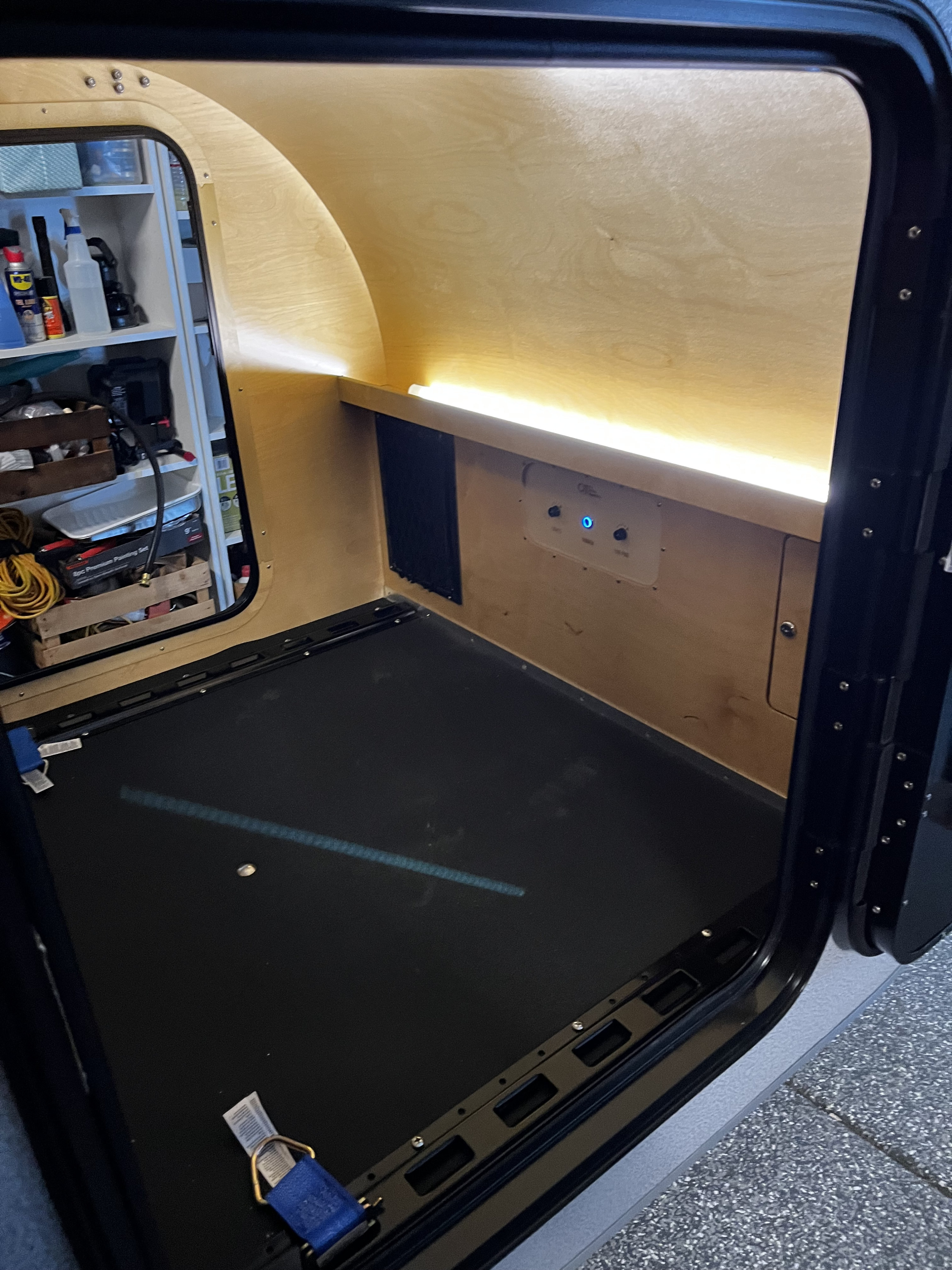 Inside an RV rental: Wood-paneled sleeping area, bright LED lighting, control panel, and left-side storage.. Oregon Trail’R DoDrop 2024