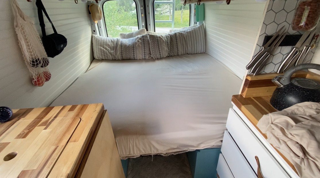 Inside a well-organized rv rental campervan: large bed, smart storage, and a compact kitchen. Ready for travel!. Ford Transit 2019