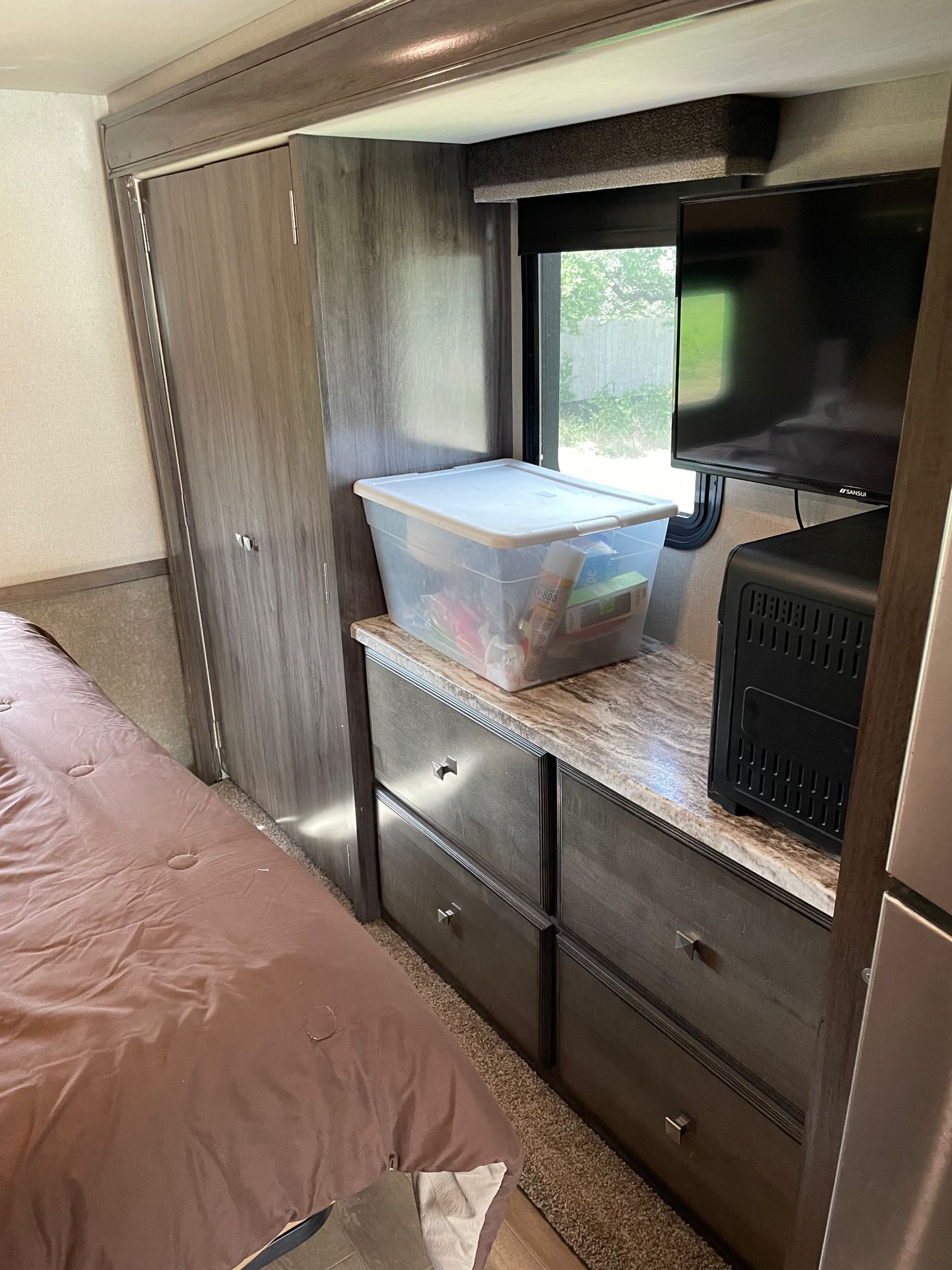 Cozy RV rental bedroom showing bed, closet, dresser with TV, and storage for essentials. Ideal for travel.. Holiday Rambler Admiral 2019