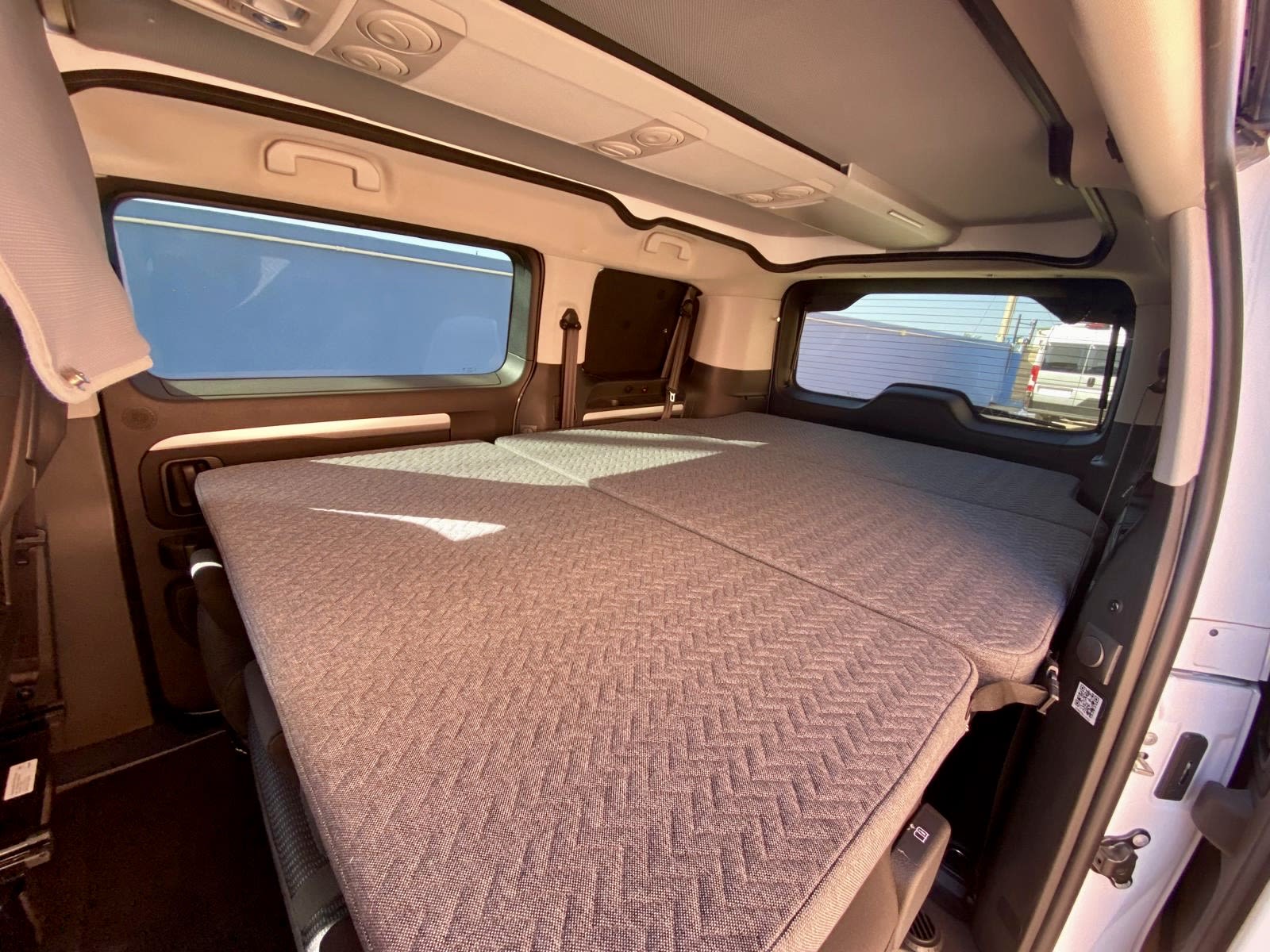 Spacious camper van rv rental interior with a comfortable, flat bed setup, perfect for your next travel adventure.. Adria Mode 2024