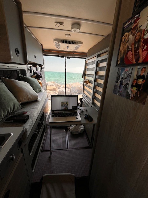 RV rental: Remote work setup in a camper van with a stunning ocean view, perfect for digital nomads from their mobile office.. Winnebago Solis 2023