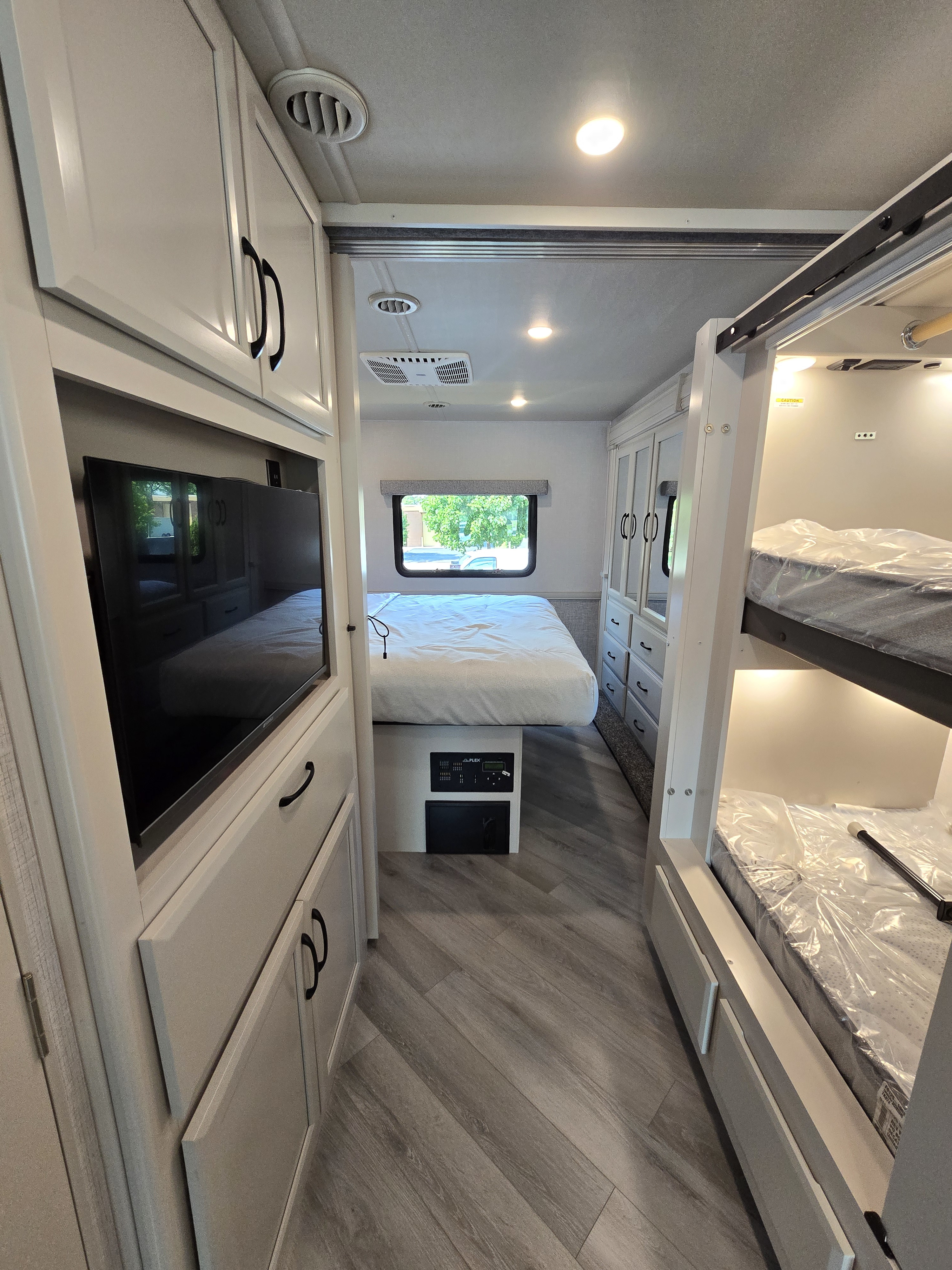 This RV rental offers a spacious interior: queen bed, bunk beds, TV, and stylish light-colored cabinetry for comfort.. Fleetwood Flex 2024
