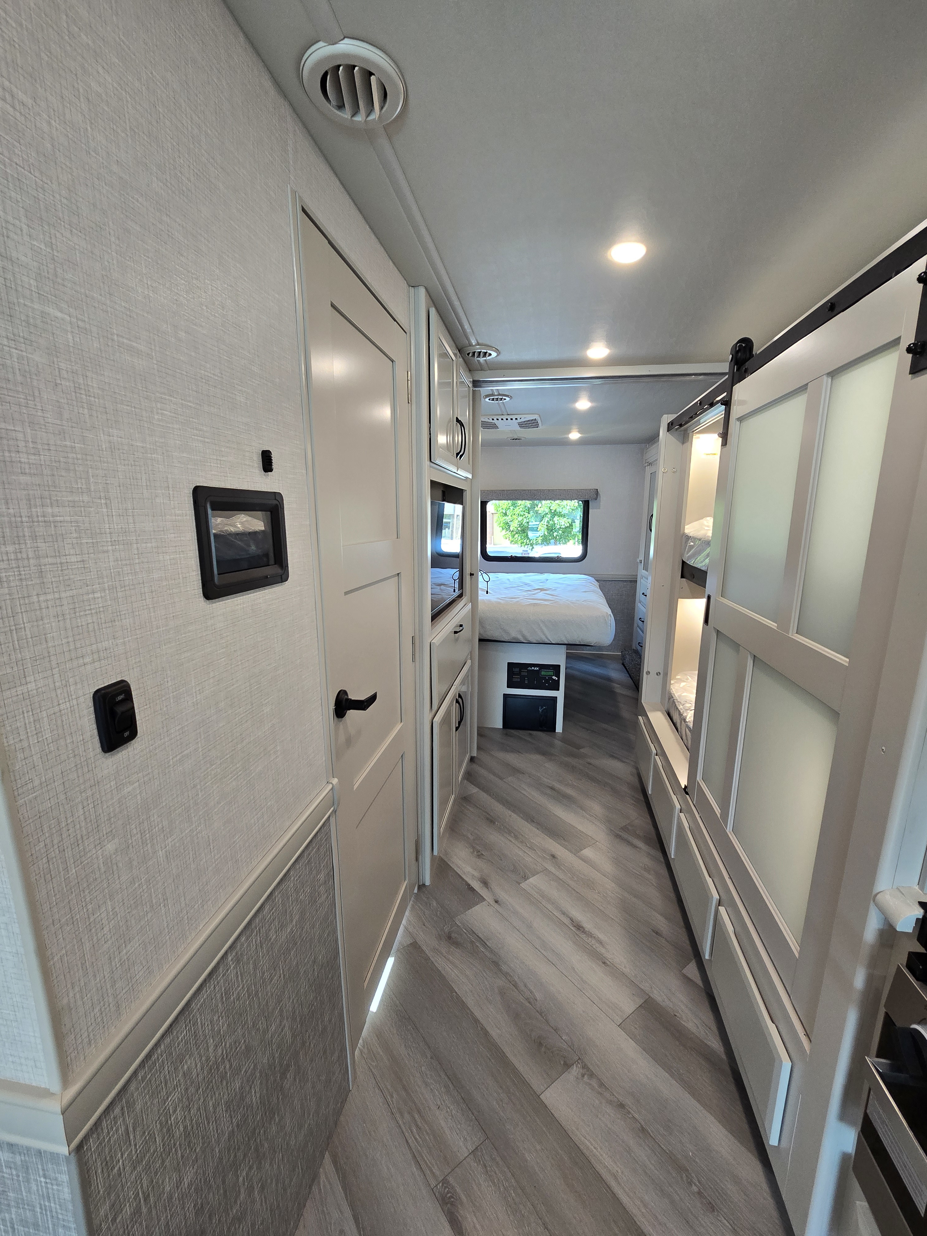 RV rental interior showing a clean hallway, primary bedroom, and bunk bed area for comfortable travel.. Fleetwood Flex 2024