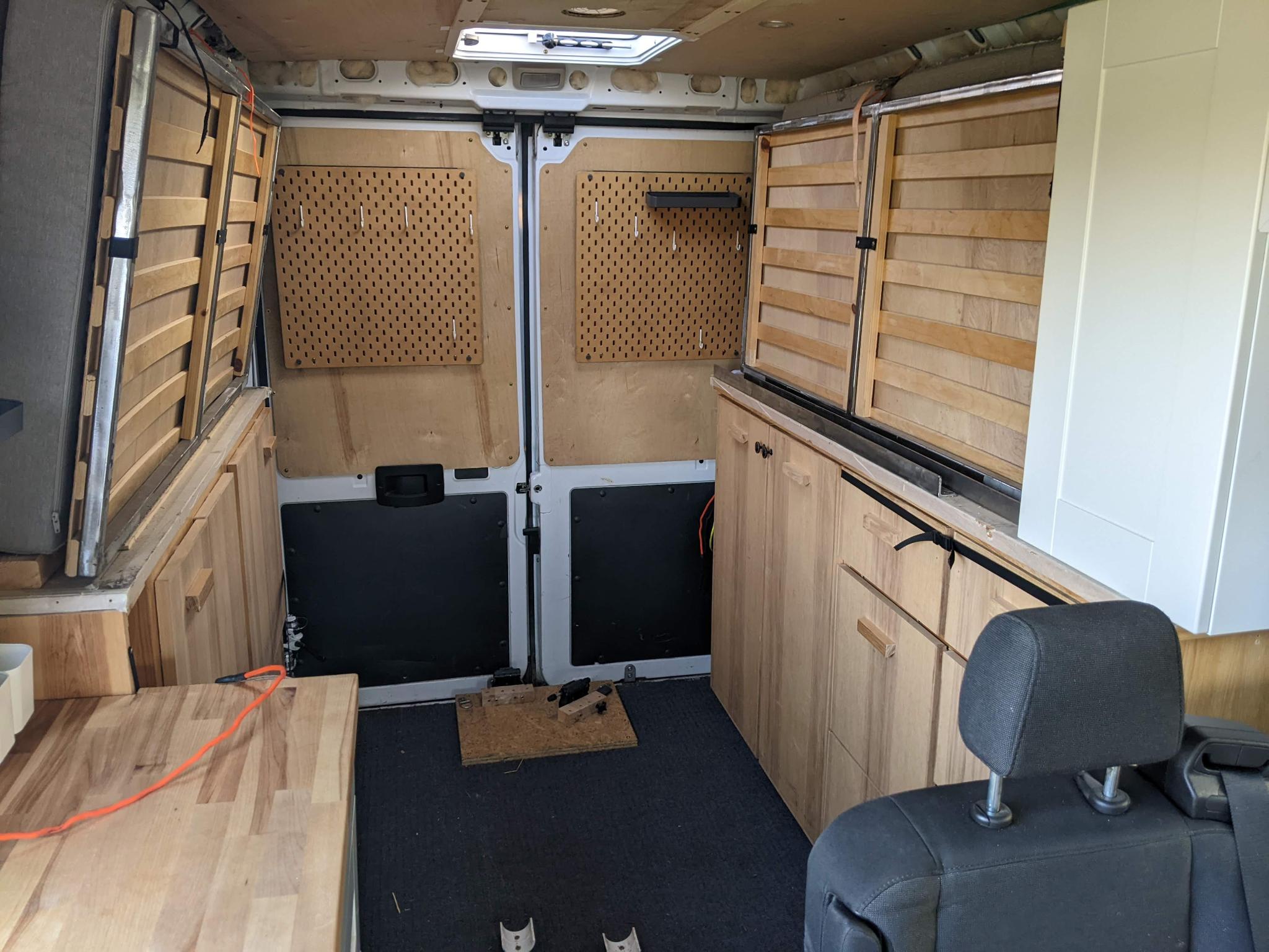 View of an RV rental's cozy custom interior, showcasing warm wood cabinetry, ample storage, and functional pegboards.. Dodge Sprinter 2500 170ext 2017