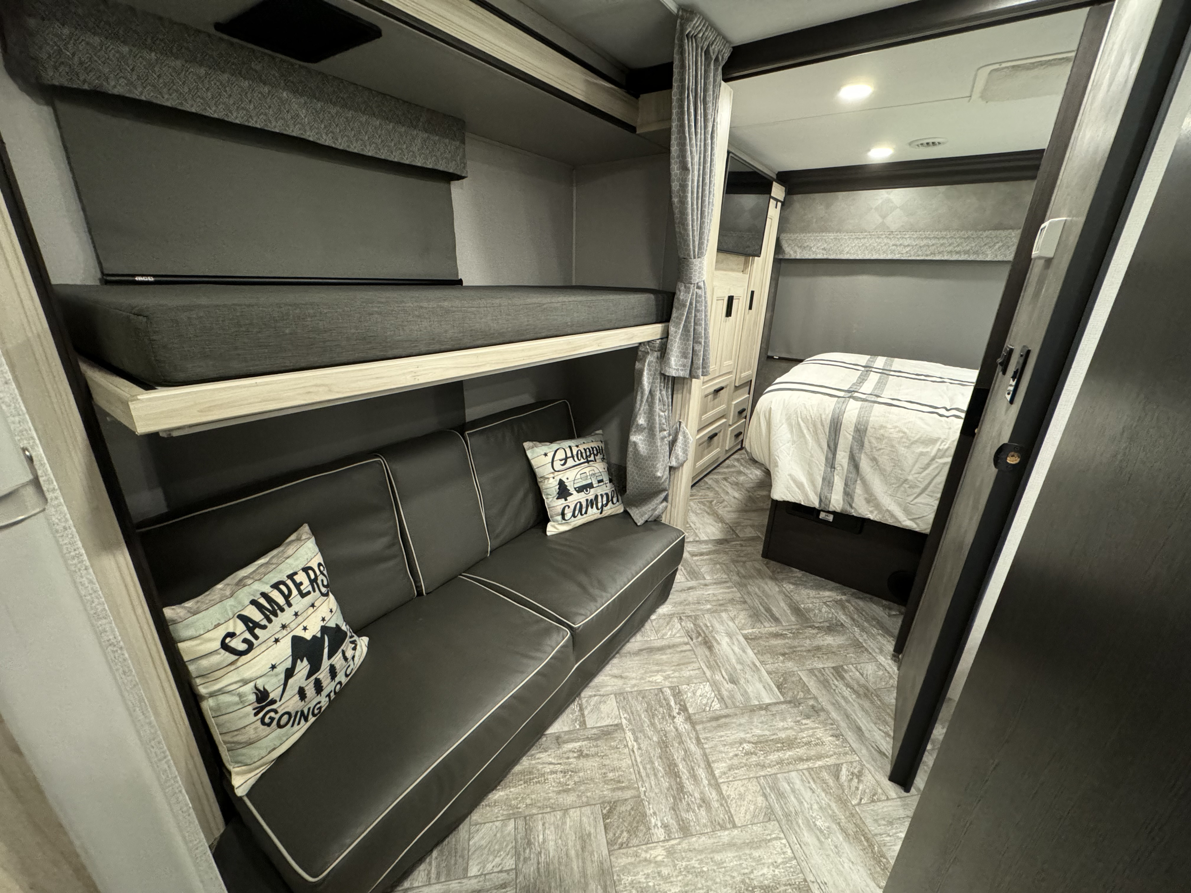 RV rental interior showcasing cozy bunk beds, a comfy sofa, and a private bedroom area for ideal family travel.. Forester LE 2022