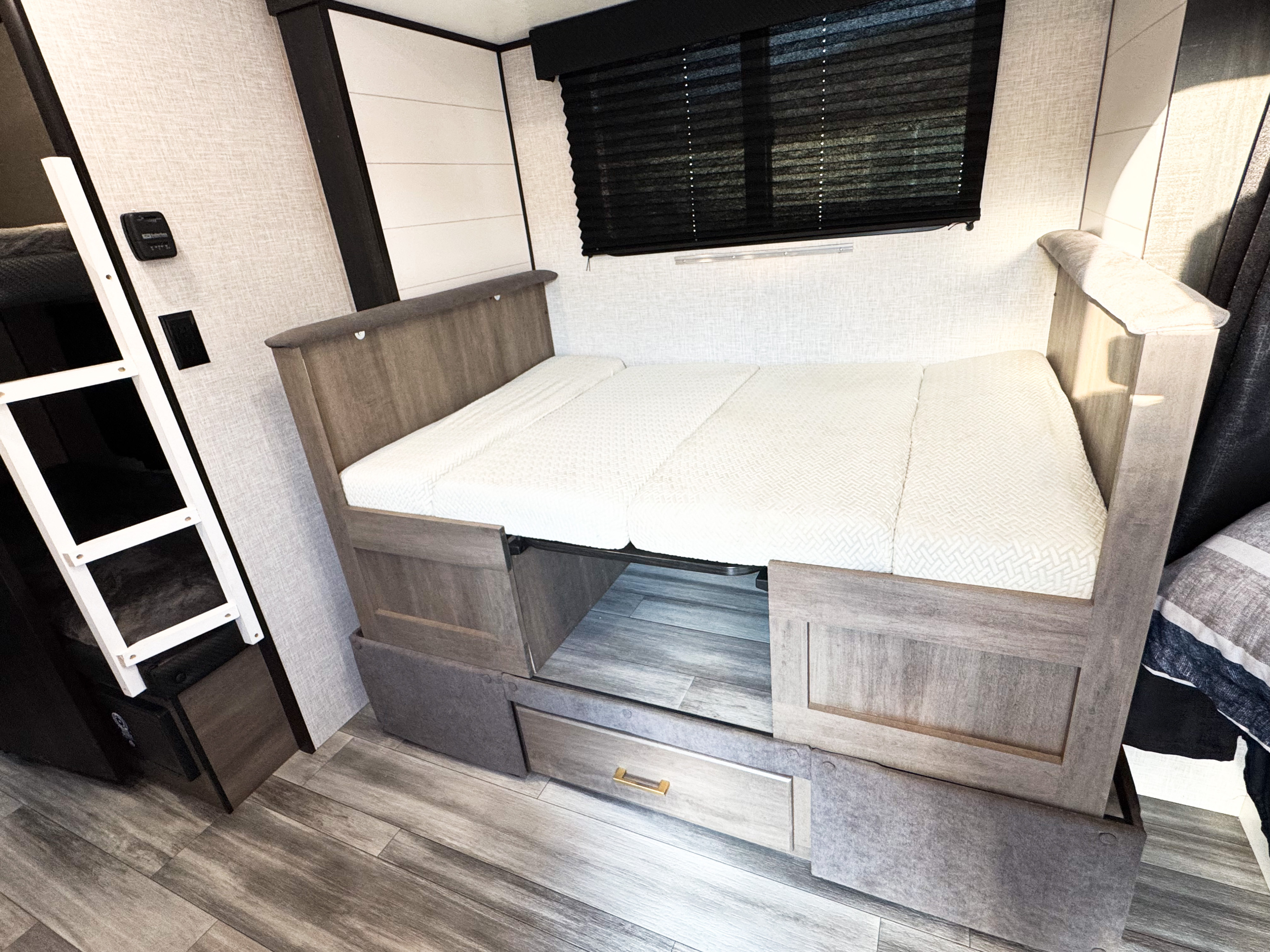 RV rental interior showcasing a versatile convertible bed with storage and a bunk bed, ready for your next adventure.. Jayco Jay Flight SLX Baja Edition 2024