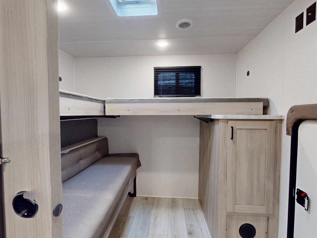 This RV rental offers a versatile interior with a convertible sofa and comfortable bunk beds, perfect for family travel.. East to West Silver Lake 3250QB 2025