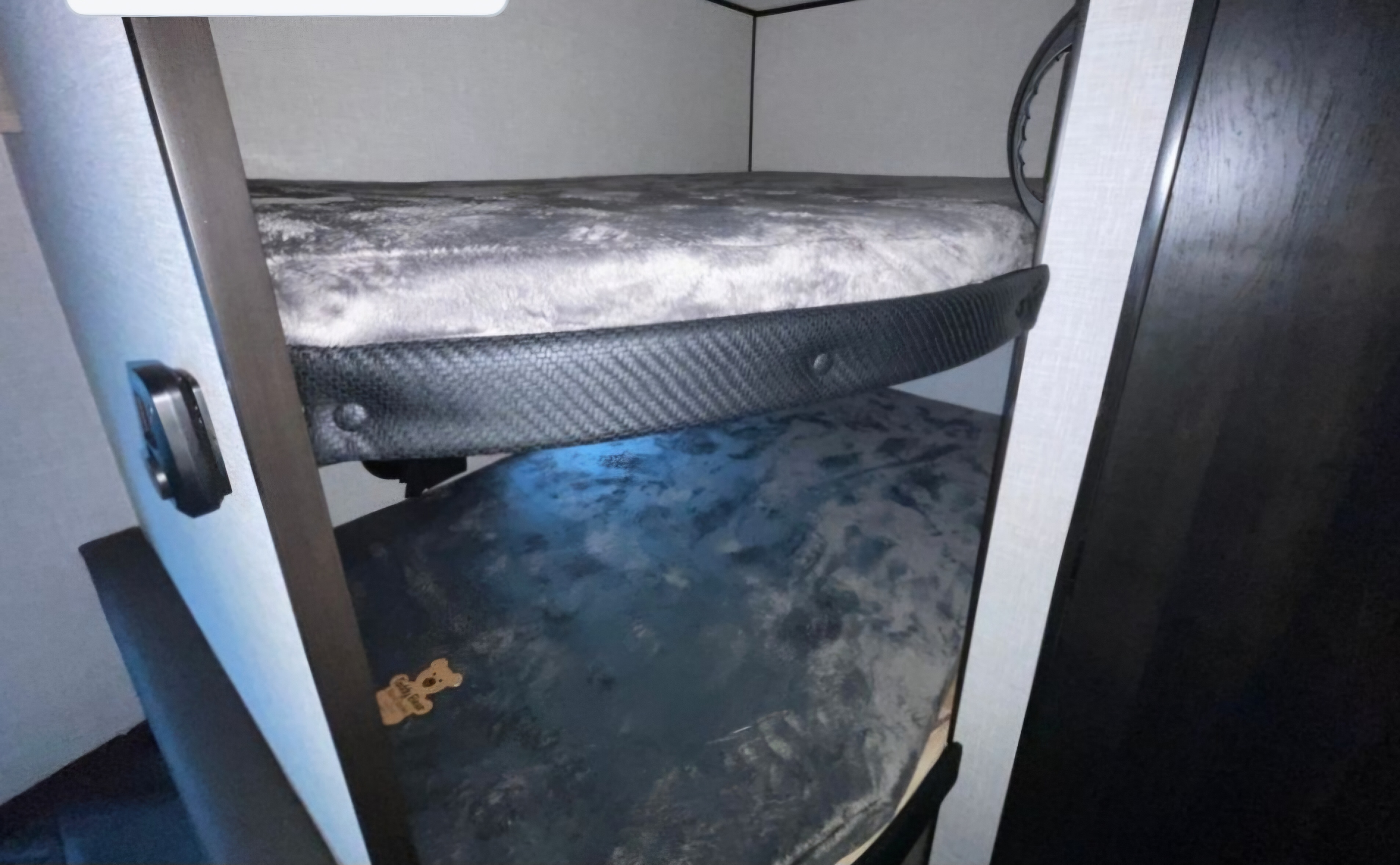 Cozy RV rental bunk beds with soft grey plush bedding, offering a compact and comfortable sleeping area inside the vehicle.. Jayco Jay Flight SLX 2024