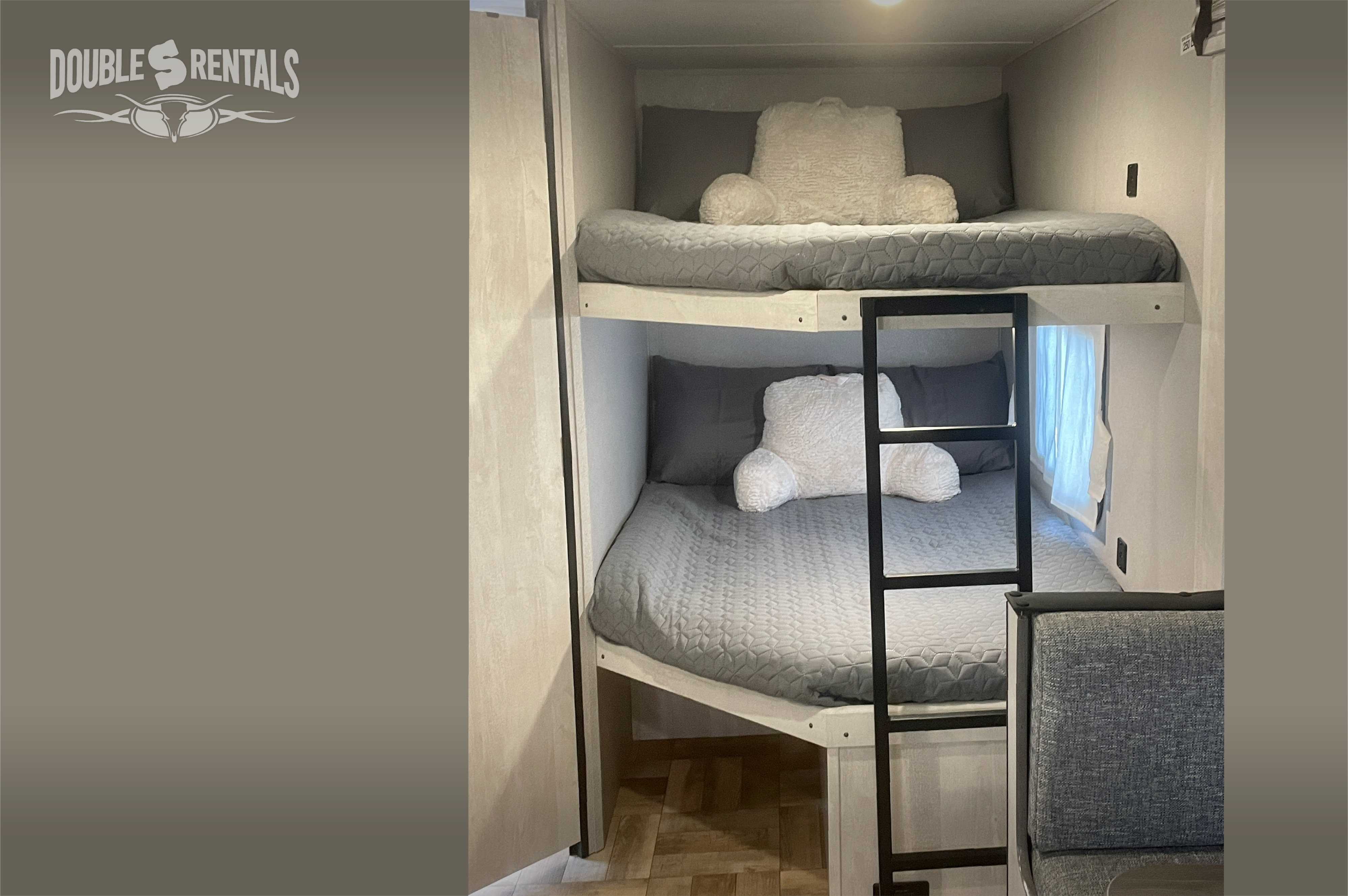 RV rental with cozy bunk beds. This travel trailer's sleeping area features two levels, grey bedding, and a ladder for comfort.. Shasta 26DB 2022