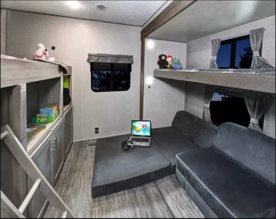 RV rental bunkhouse featuring two sets of bunks, lower convertible sofa, and integrated storage for a family-friendly space.. Forest River Aurora Aurora 2022