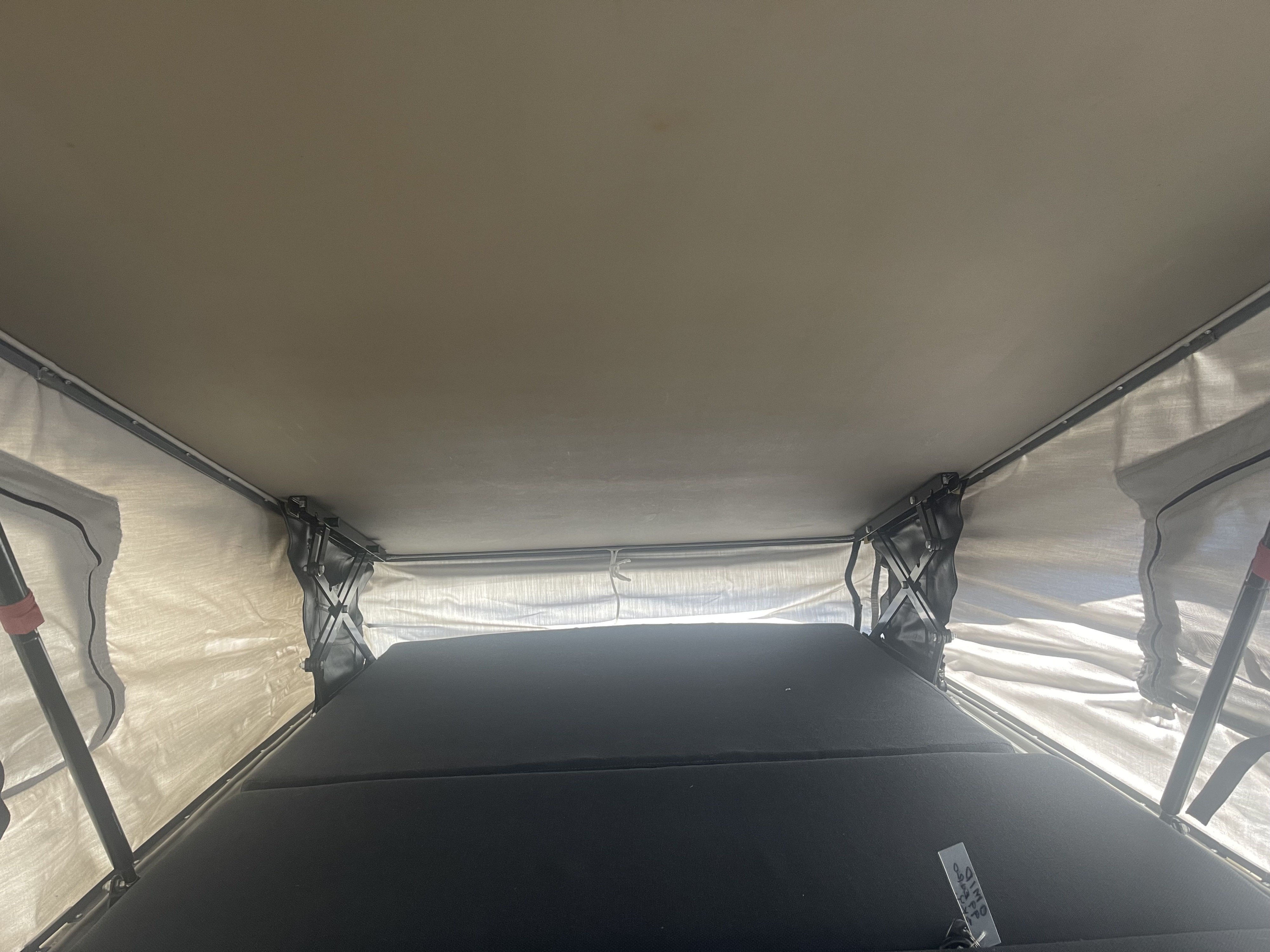 Interior of an RV rental: a spacious pop-top camper tent showing the bed and structural supports.. Volkswagen Winnebago Leisure Seeker 1999