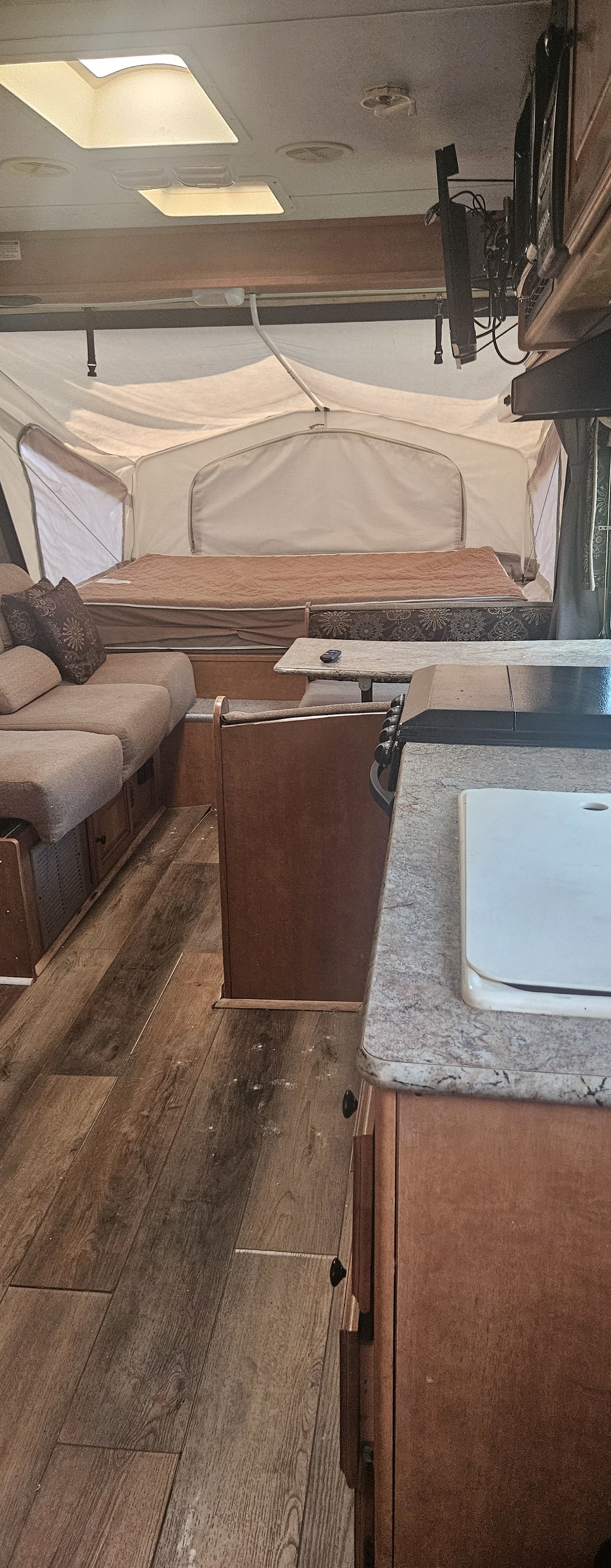 Spacious RV rental interior with lounge seating, dining table, kitchen counter, and pop-out tent bed area.. Palomino Stampede 2013