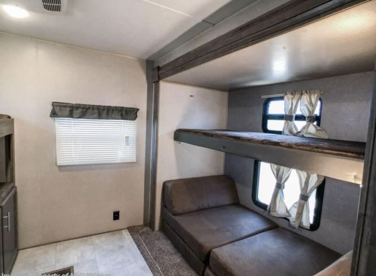 RV rental: Cozy bunkhouse interior with stacked beds, comfy sofa seating, and multiple windows.. Forest River Aurora Aurora 2022