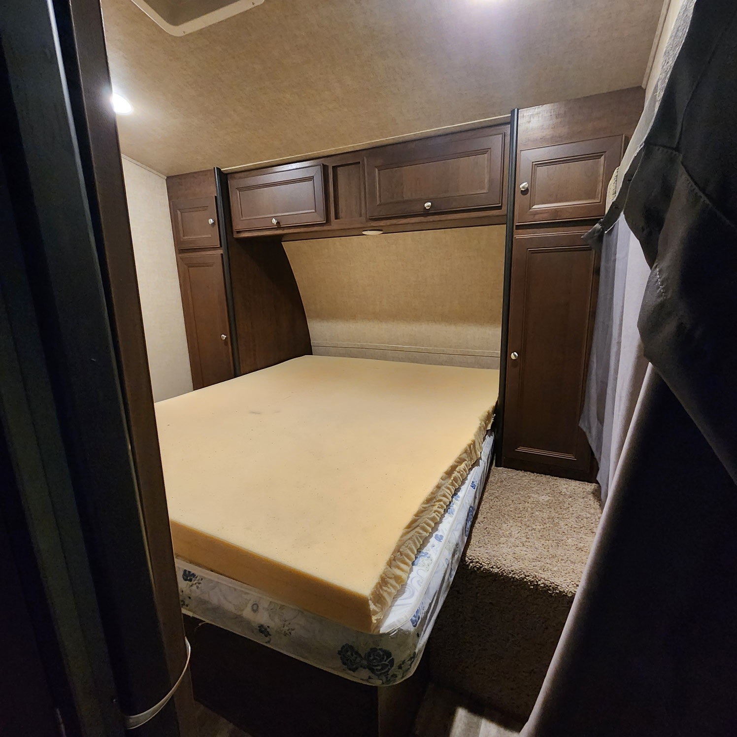 Compact RV rental bedroom with a bed, foam topper, and built-in cabinets for storage.. Keystone Impact 2015