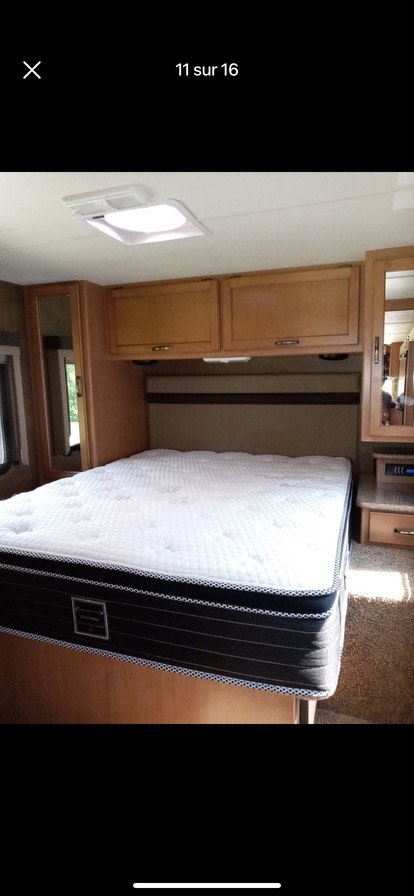 RV rental bedroom featuring a plush mattress, built-in wooden cabinets, and bright overhead lighting. A comfortable interior.. A.C.E. A.C.E. Motorhome 2015
