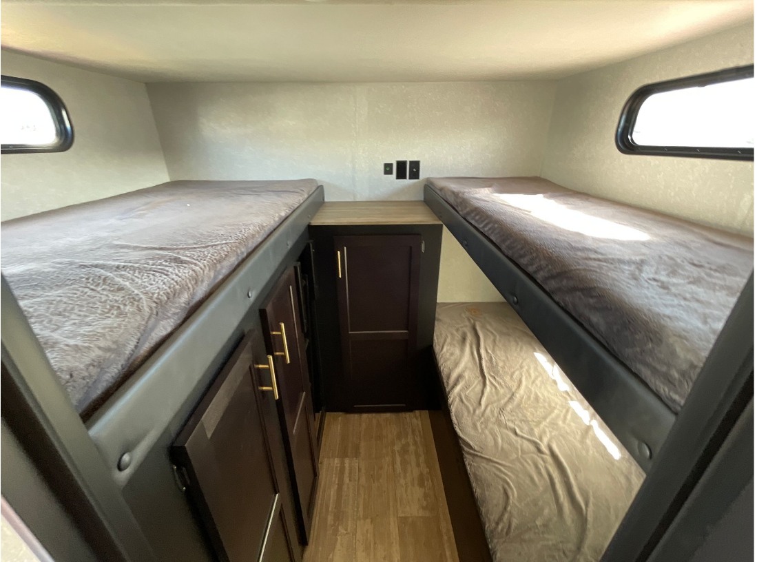 RV rental bunk room: Bright interior with three beds, central storage, and large windows. Perfect for group adventures.. Forest River Cherokee Grey Wolf Black Label 2021