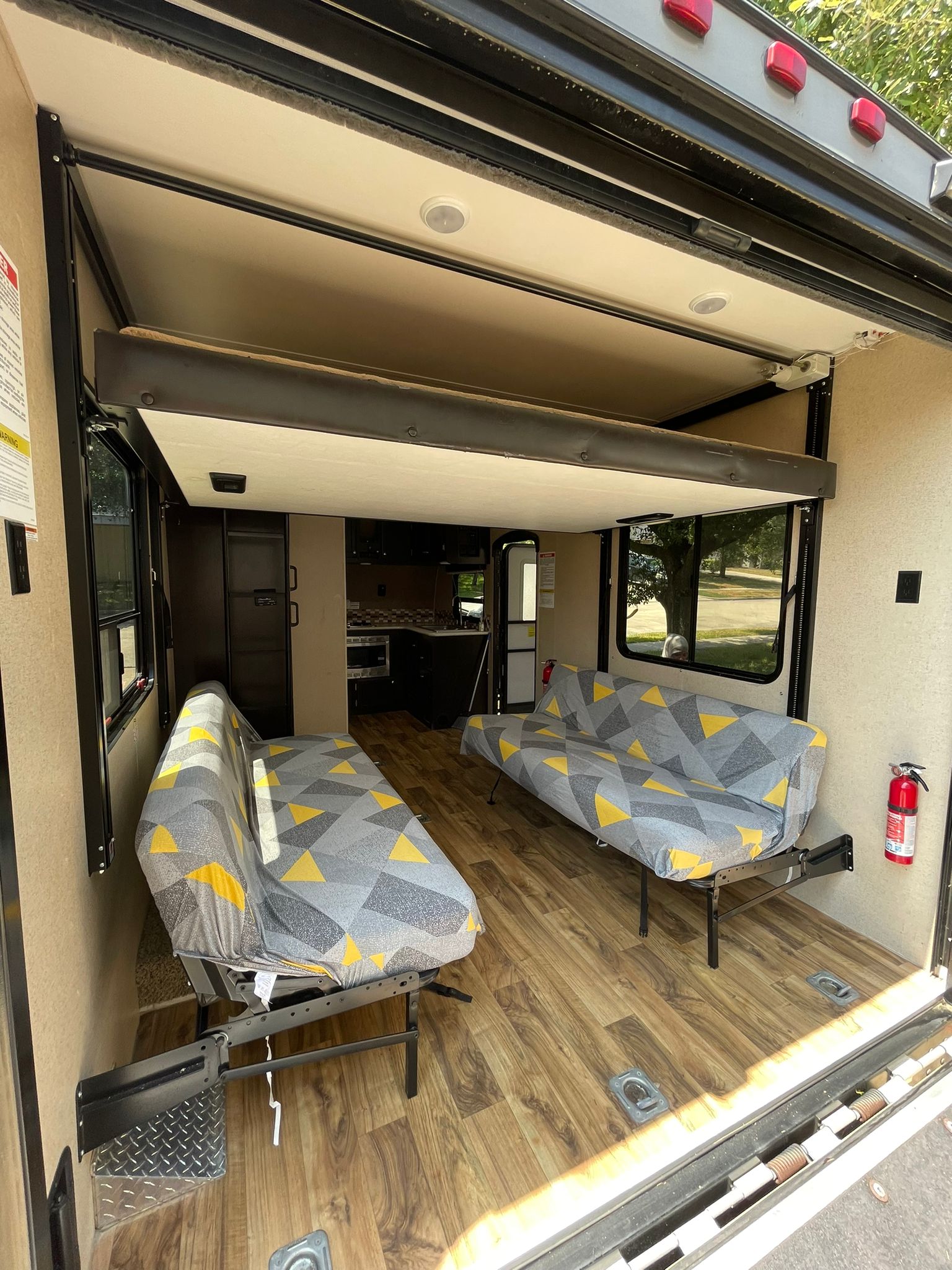 RV rental toy hauler interior. Features include fold-down sofas, an upper bunk bed for sleeping, and a full kitchen area.. Jayco Octane 2016
