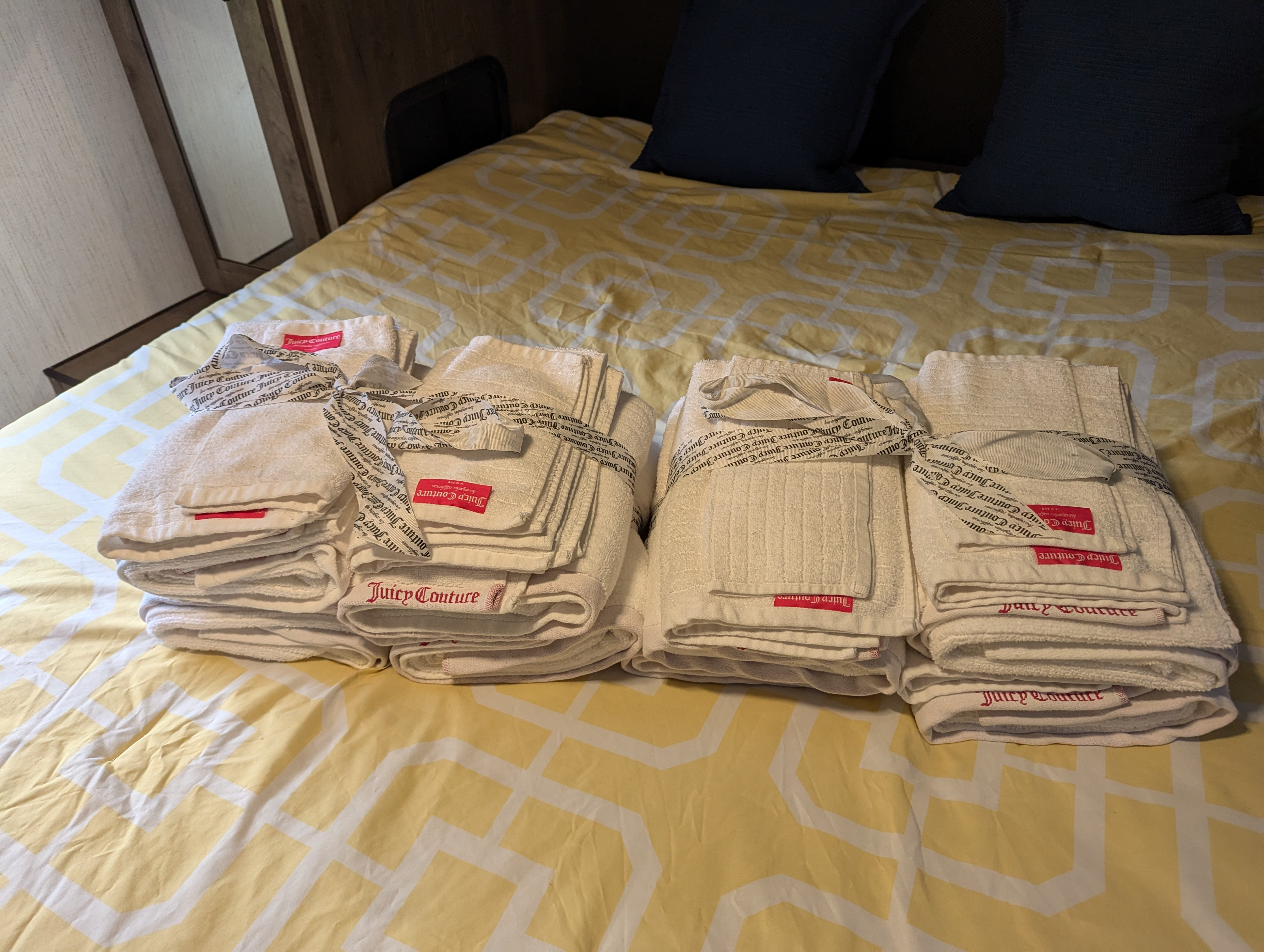 Fresh Juicy Couture towels are neatly folded on the bed in this RV rental, ready for your comfortable travels.. Heartland RVs Pioneer 2021