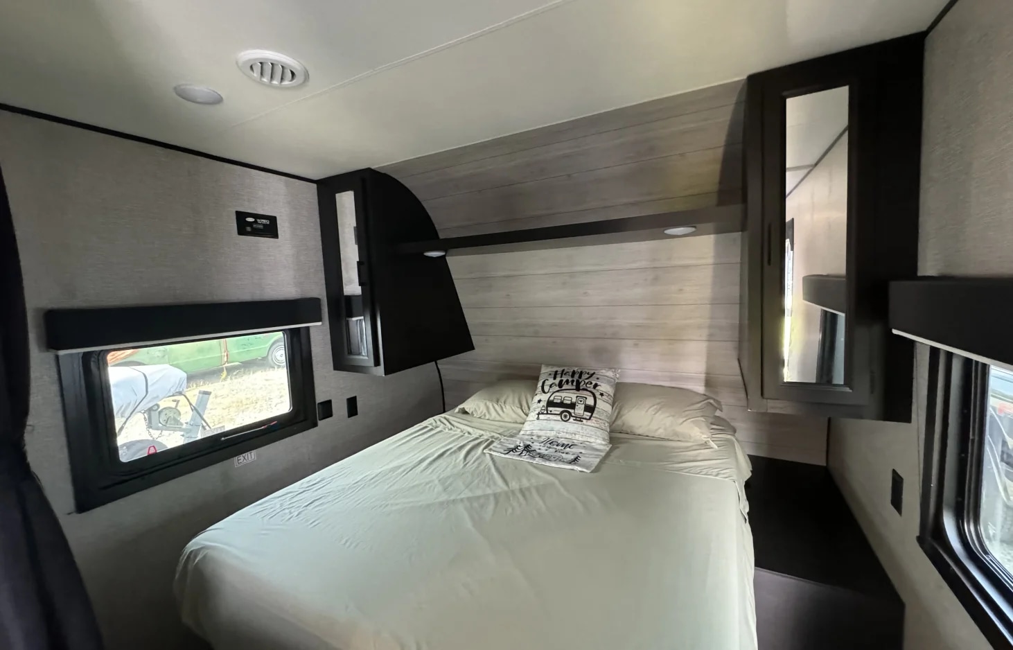 Inside this modern RV rental bedroom, find a comfortable bed, light wood paneling, and ample windows.. Jayco Jay Flight SLX 2022