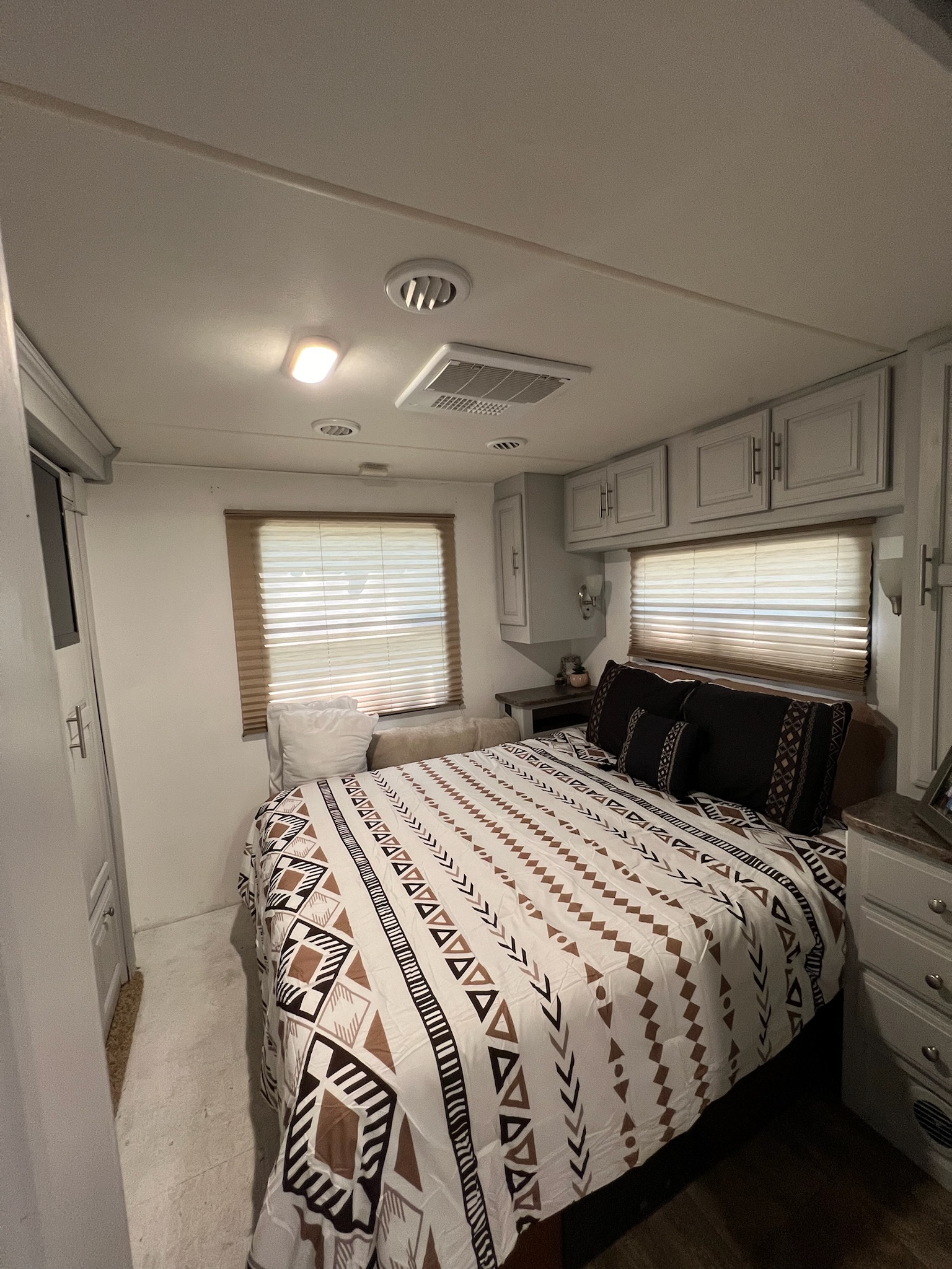 Spacious, modern bedroom inside an RV rental, featuring a comfortable bed with tribal patterns, built-in storage, and windows.. Georgetown Georgetown Motorhome 2016