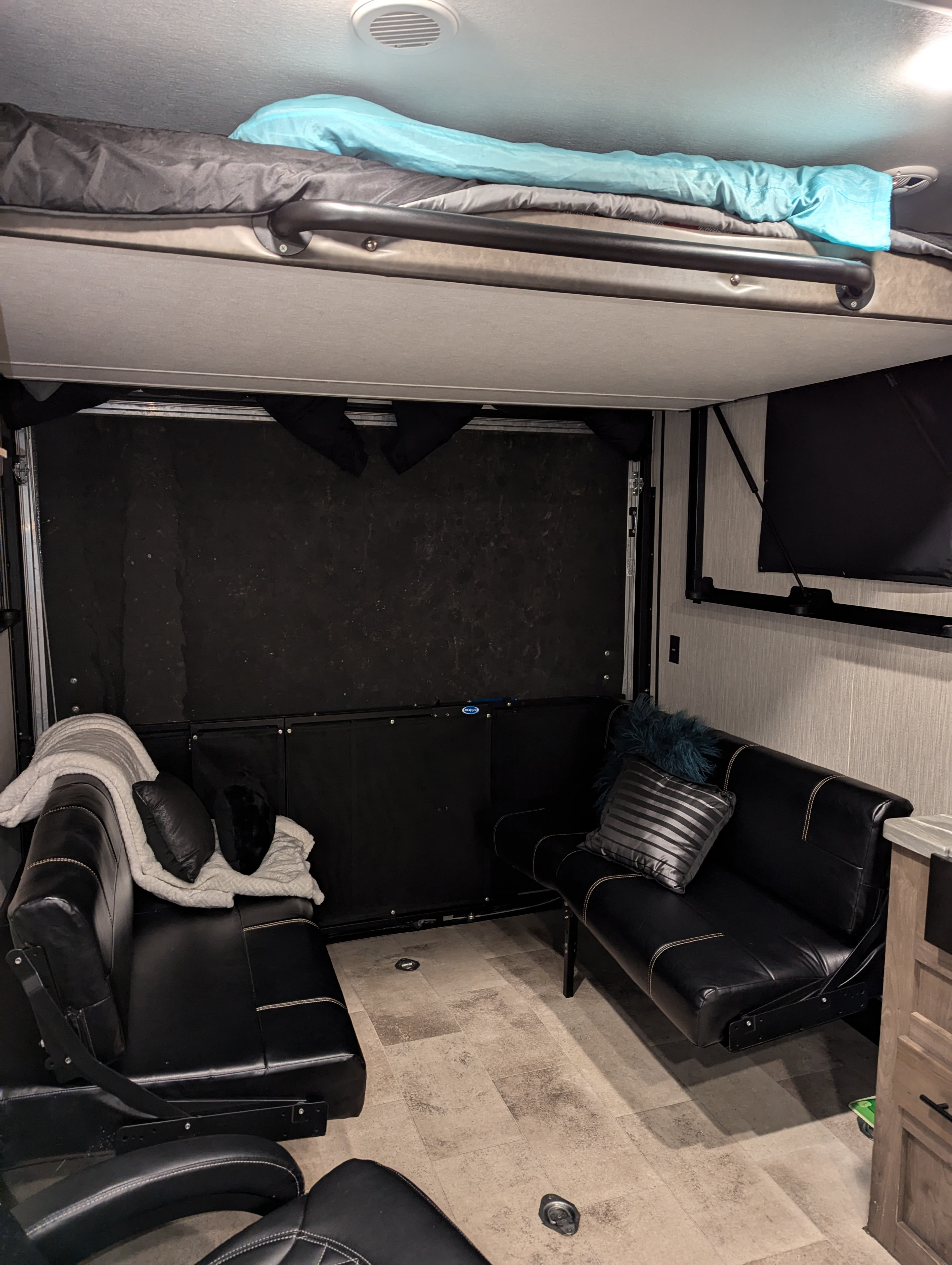 This RV rental offers a flexible interior with an overhead bunk, two black leather sofas, and a convertible rear garage space.. Forest River Vengeance Rogue Toy Hauler 2020