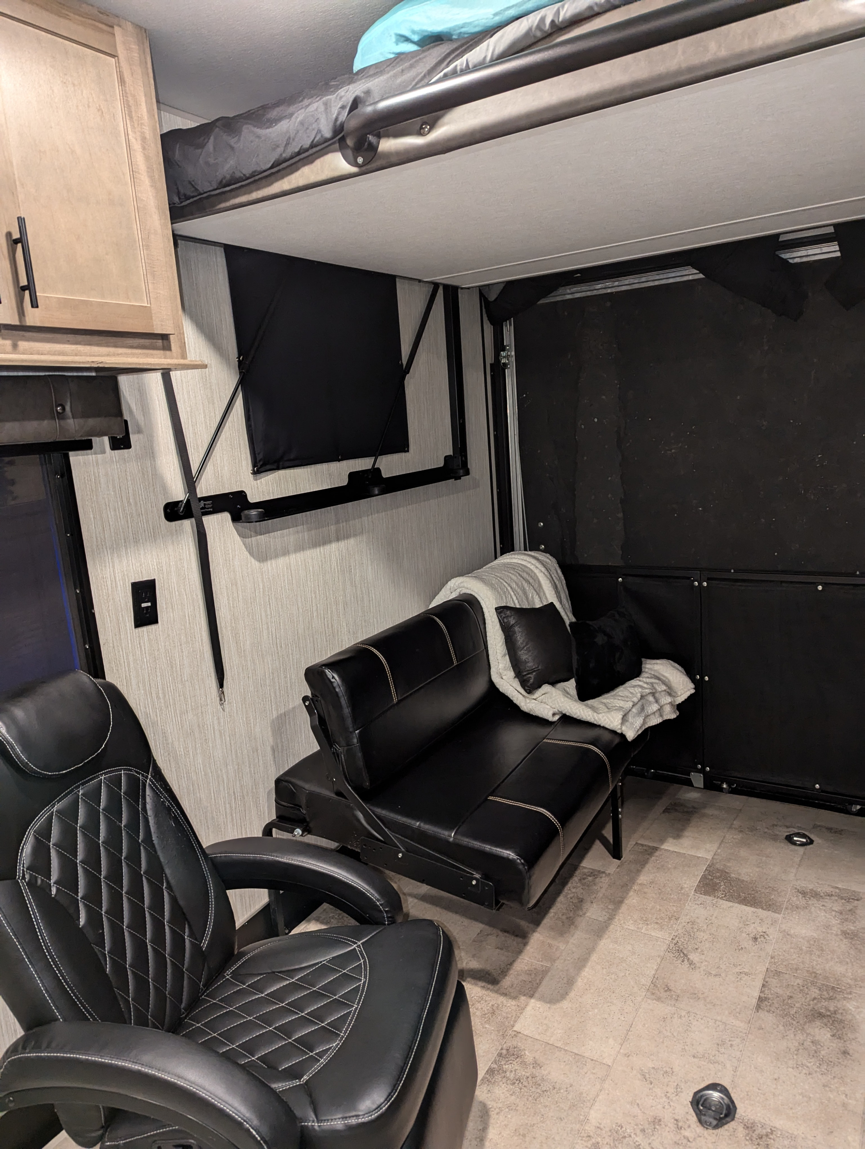 Toy hauler rv rental interior with flexible living space, convertible sofa, and upper bunk bed.. Forest River Vengeance Rogue Toy Hauler 2020