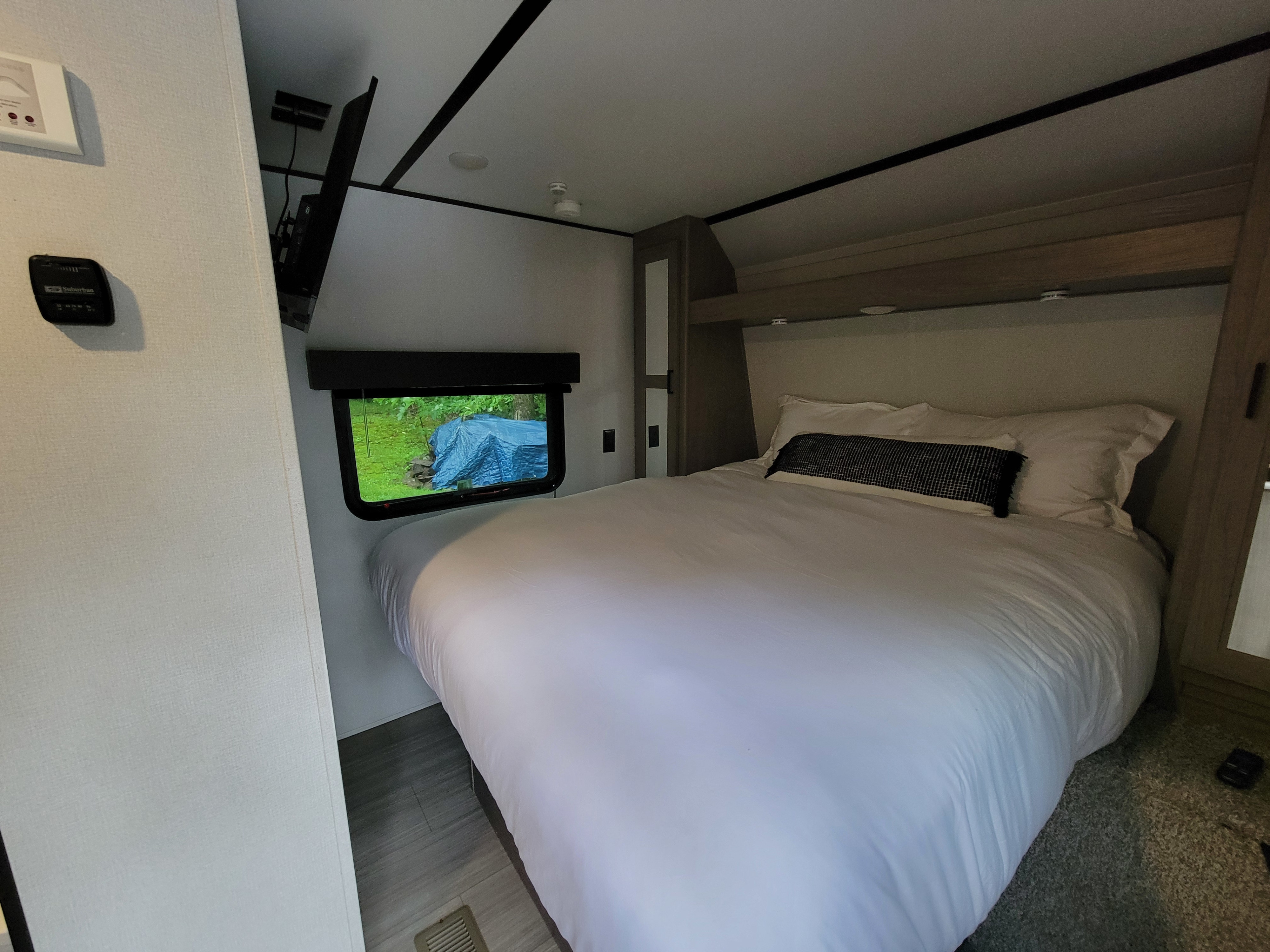 RV rental: A comfortable bedroom with crisp white bedding, a wall-mounted TV, and a scenic window view.. Keystone RV Hideout LHS 2020