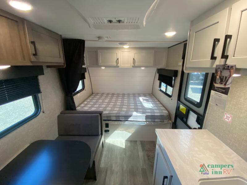 This RV rental interior shows a compact living space: a bed, dinette, and kitchen counter. Ideal for your next road trip.. Jayco Jay Flight SLX Baja Edition 2024