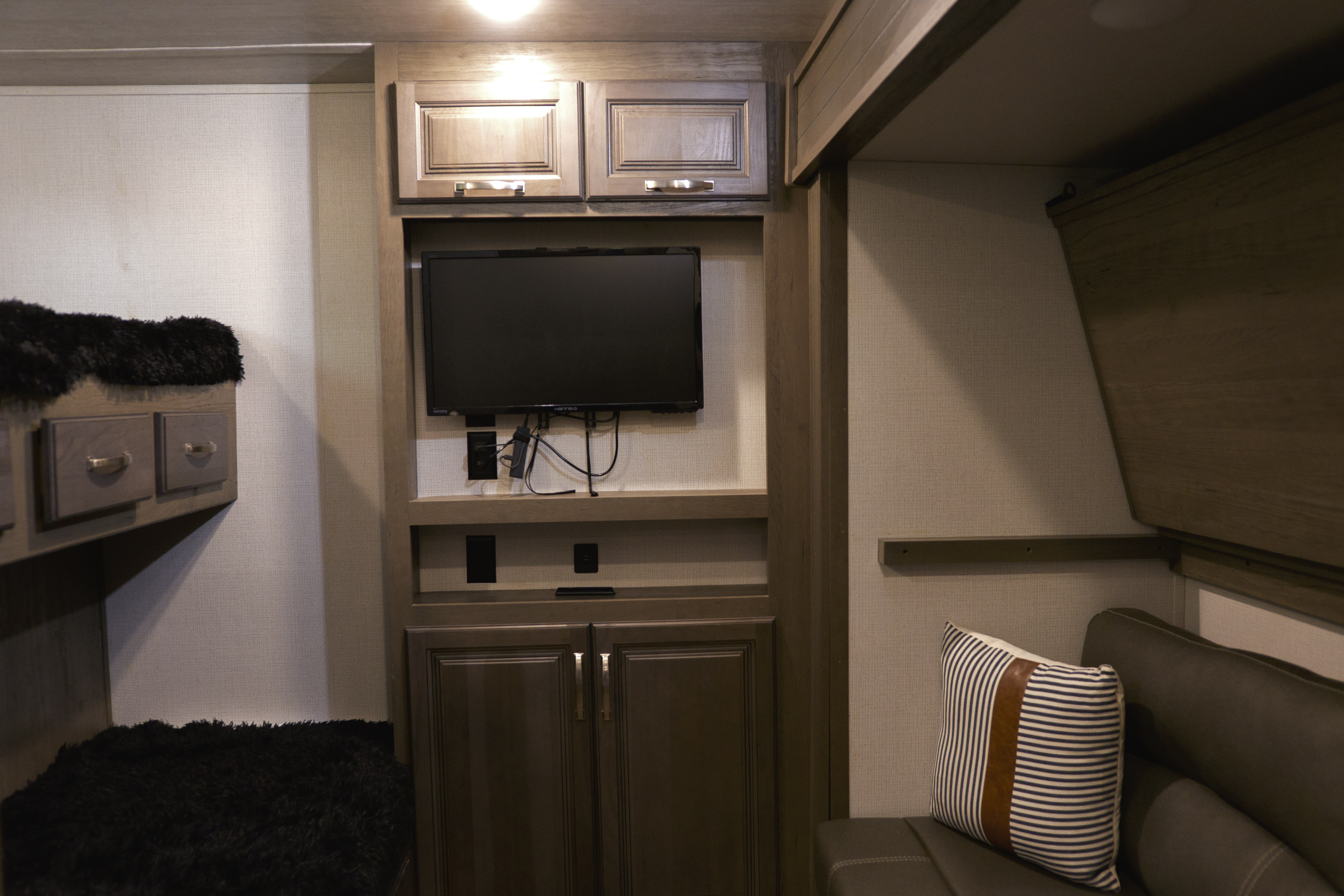 Modern RV rental interior with bunk beds, an entertainment center featuring a TV, and a cozy lounge area.. Keystone RV Cougar 2022