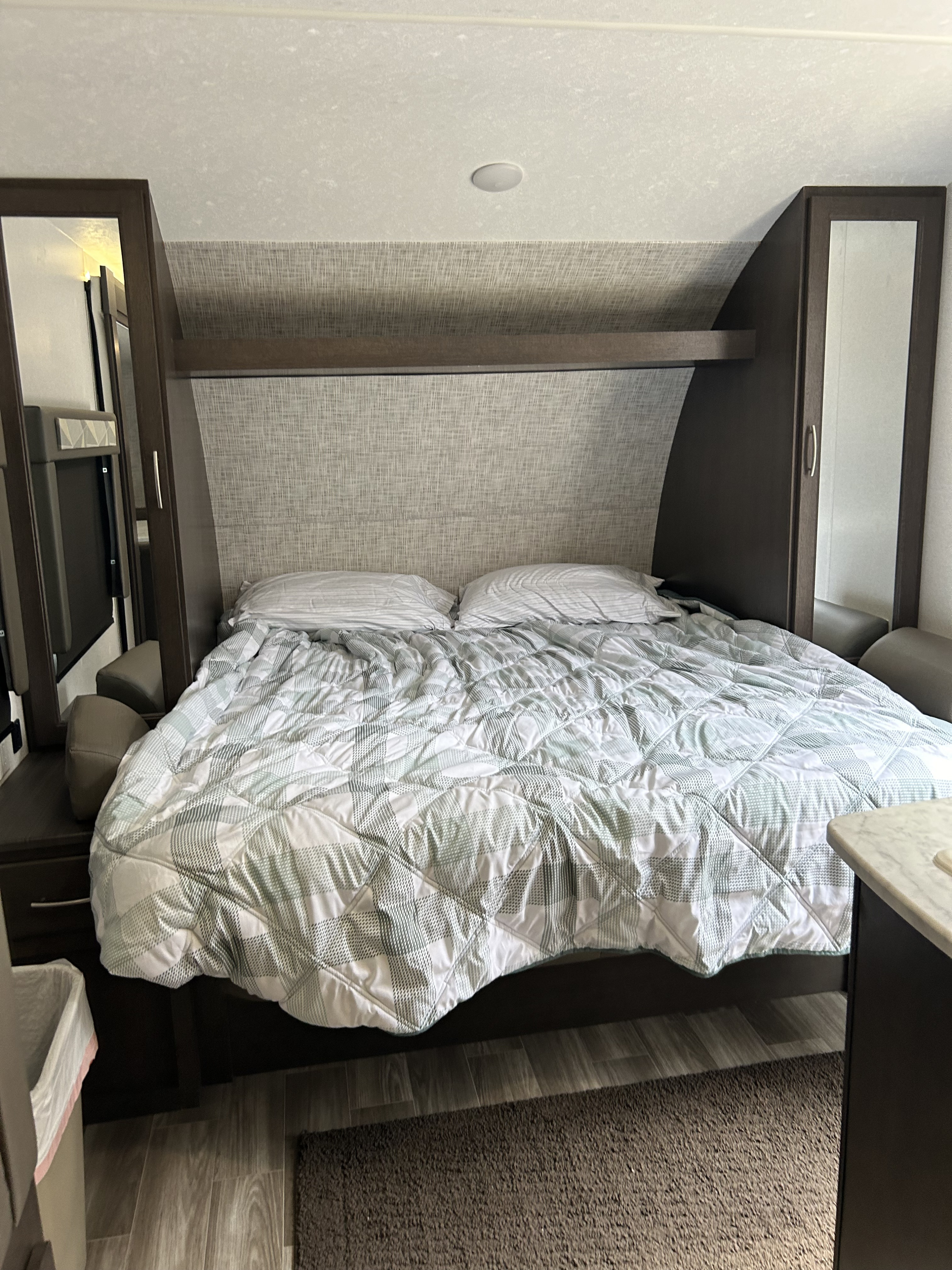 Cozy RV rental bedroom with comfortable bed and built-in storage, ideal for travel lodging.. Forest River Wildwood Cruise Lite 2019