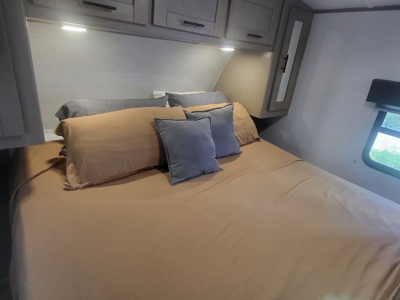 Cozy RV rental bedroom with a comfortable bed, pillows, overhead cabinets, and a window for scenic travel.. Cruiser Rv Corp Shadow Cruiser 2021